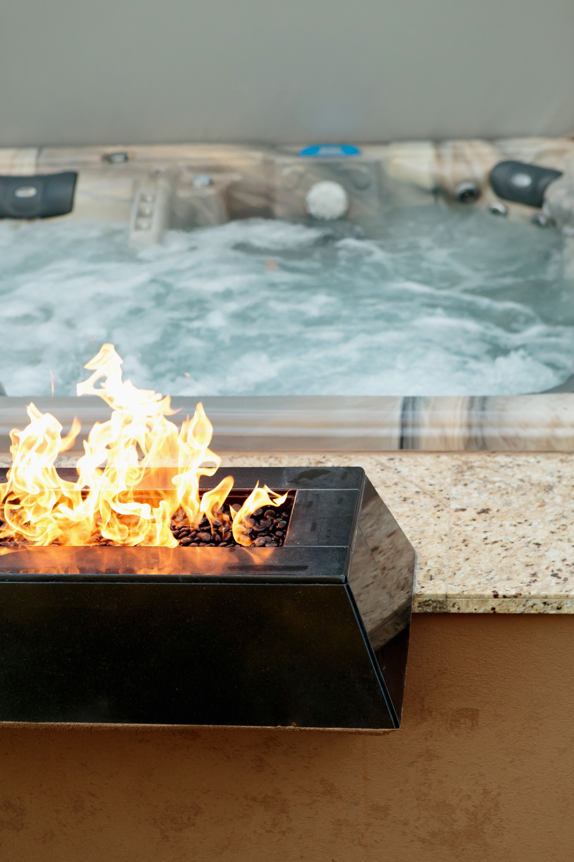 There is a fire pit in front of a hot tub.