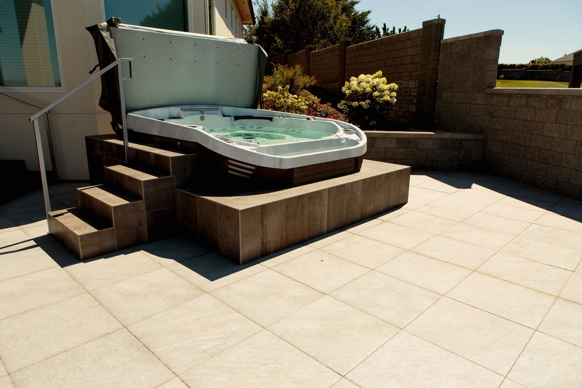 A hot tub on a patio with stairs leading up to it