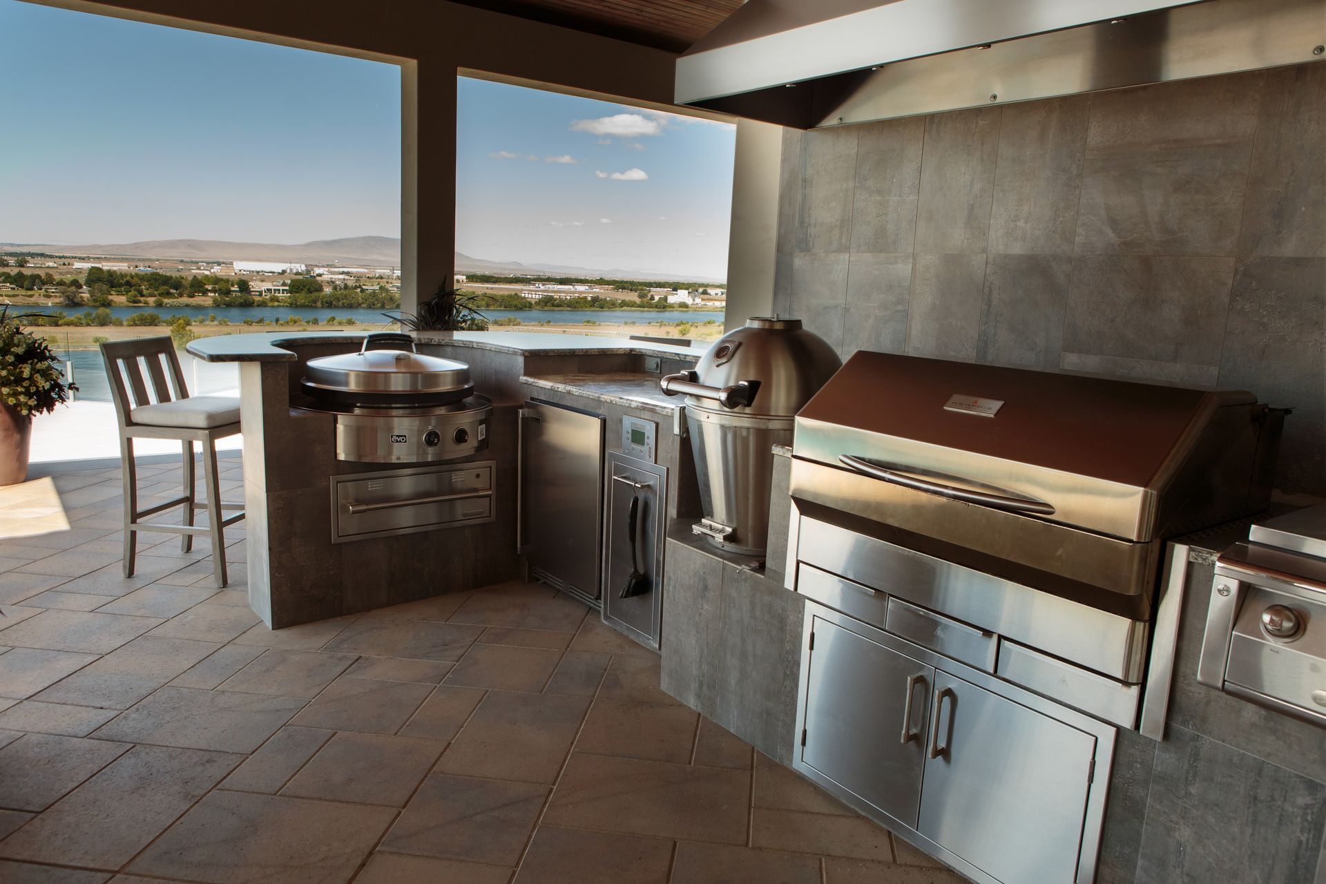 An outdoor kitchen with stainless steel appliances and a grill