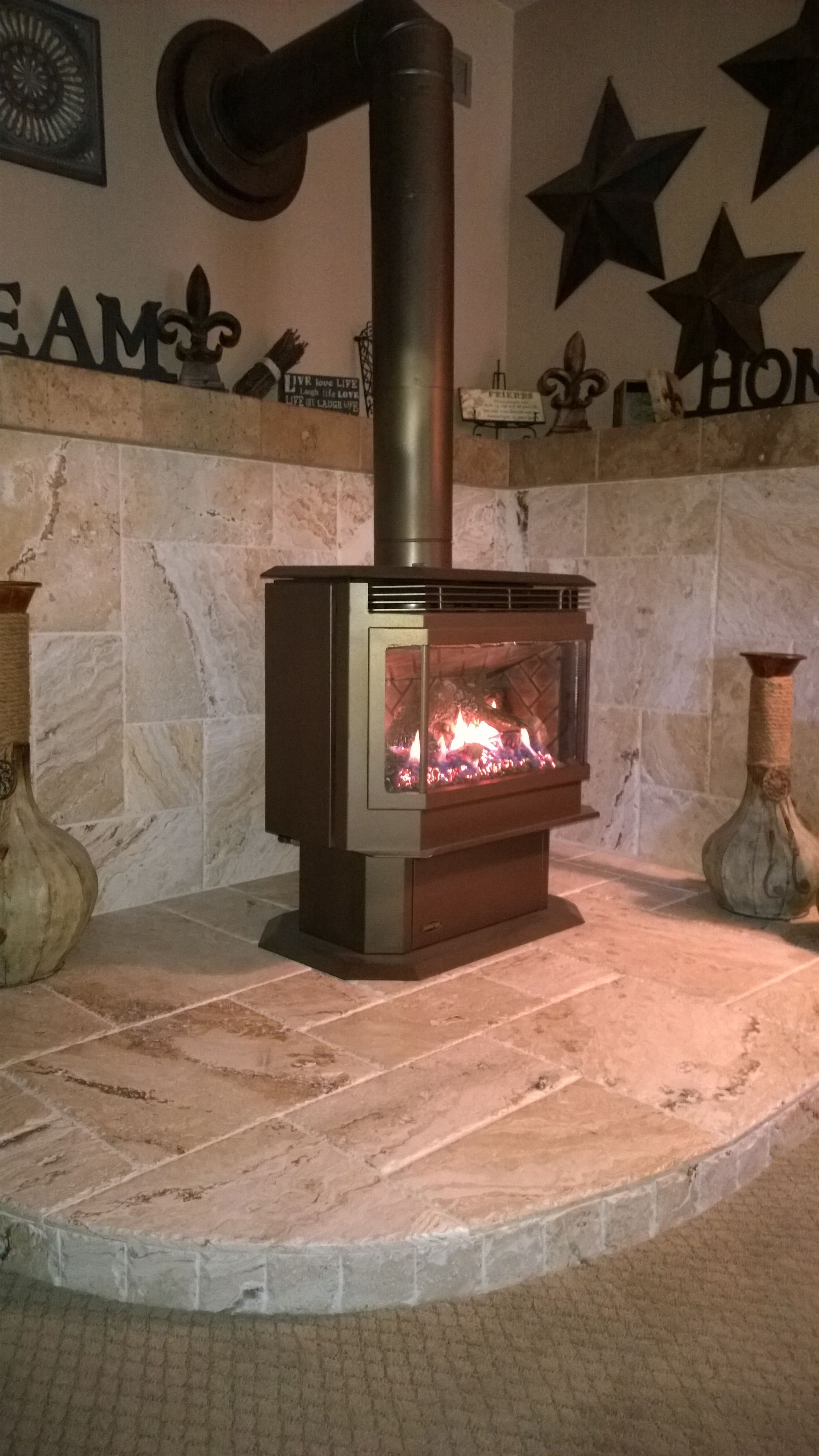 A wood stove is sitting on a tiled floor in a living room.