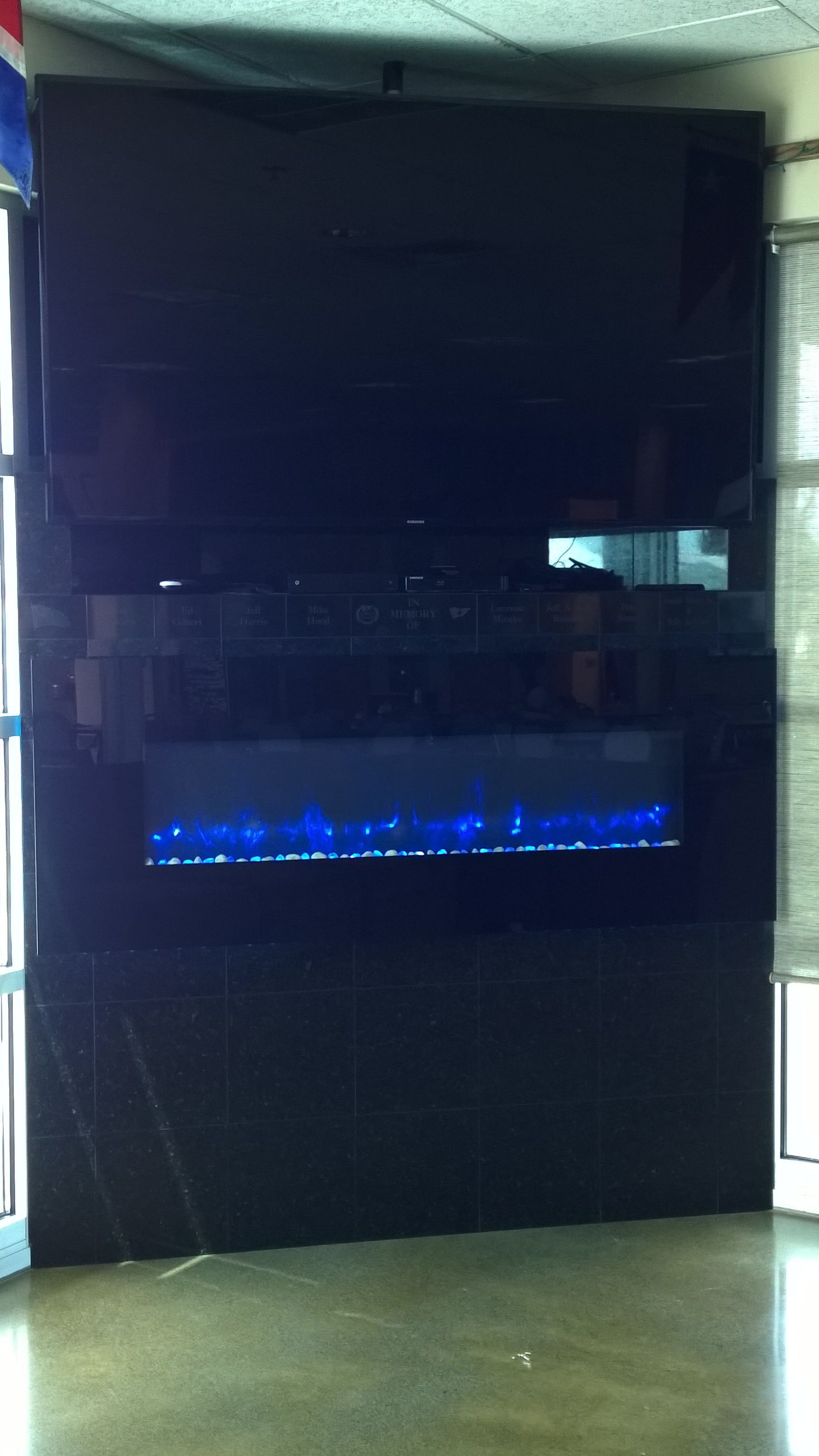 A fireplace with a flat screen tv on top of it.