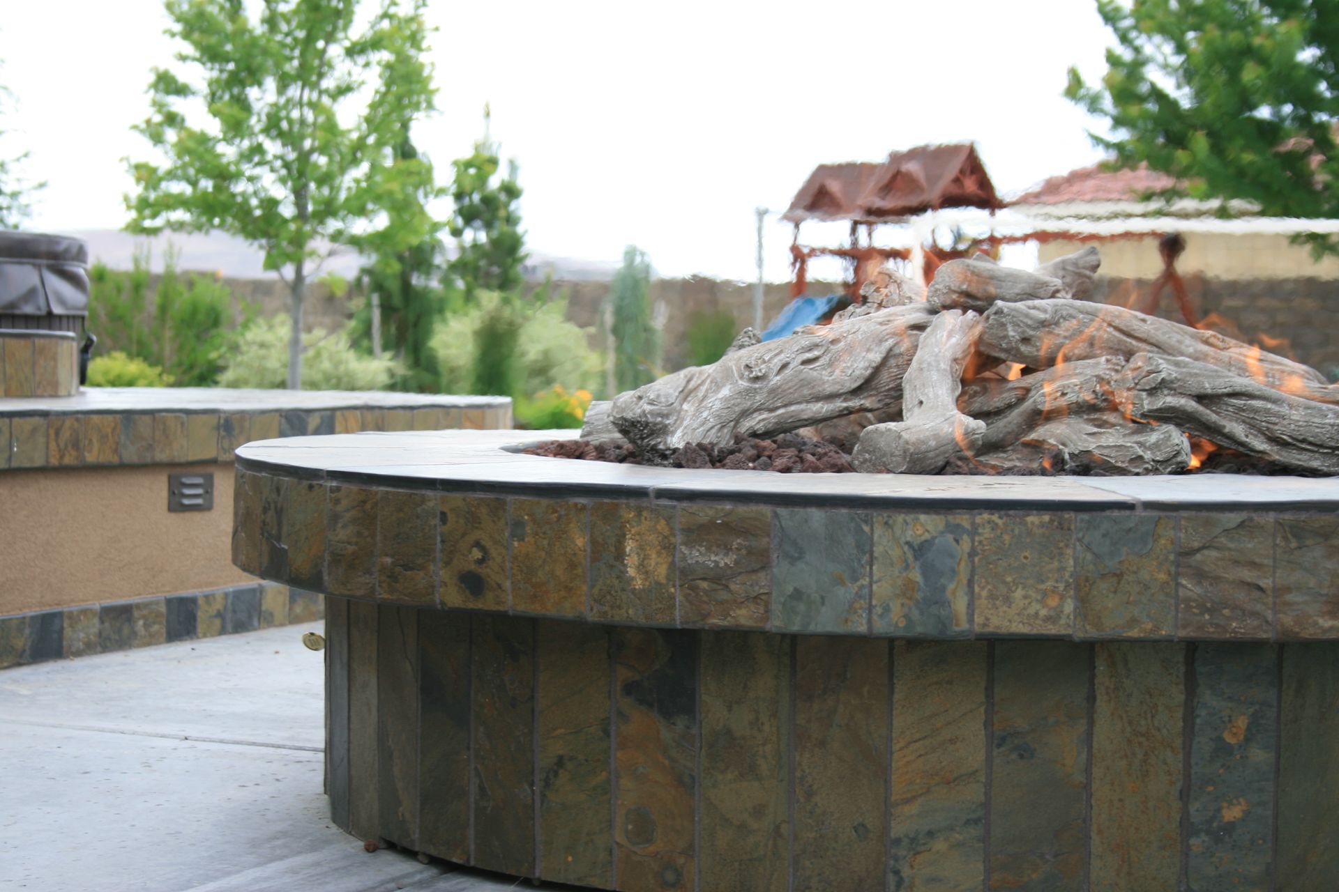 A fire pit with a playground in the background