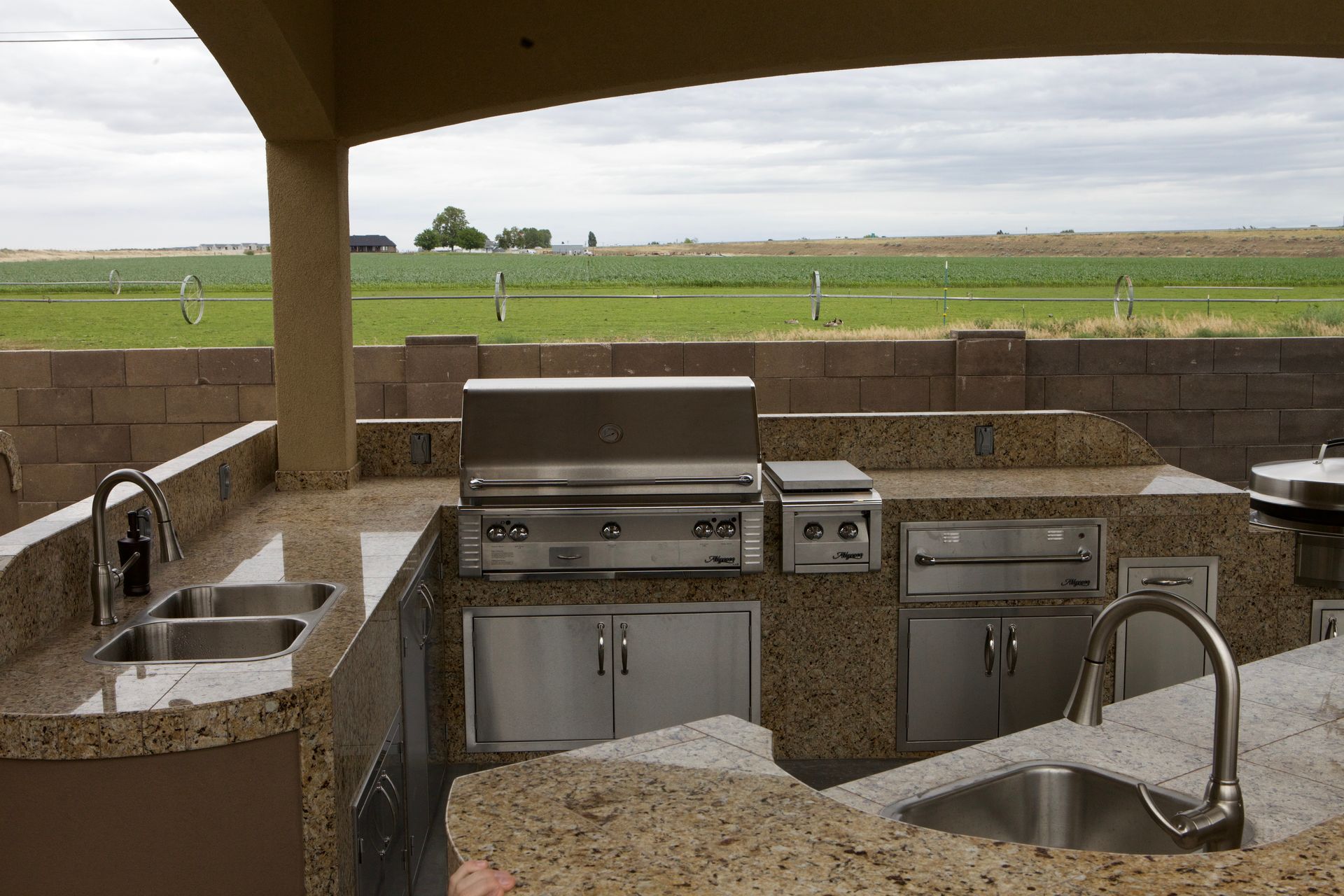 A kitchen with a stainless steel grill and two sinks