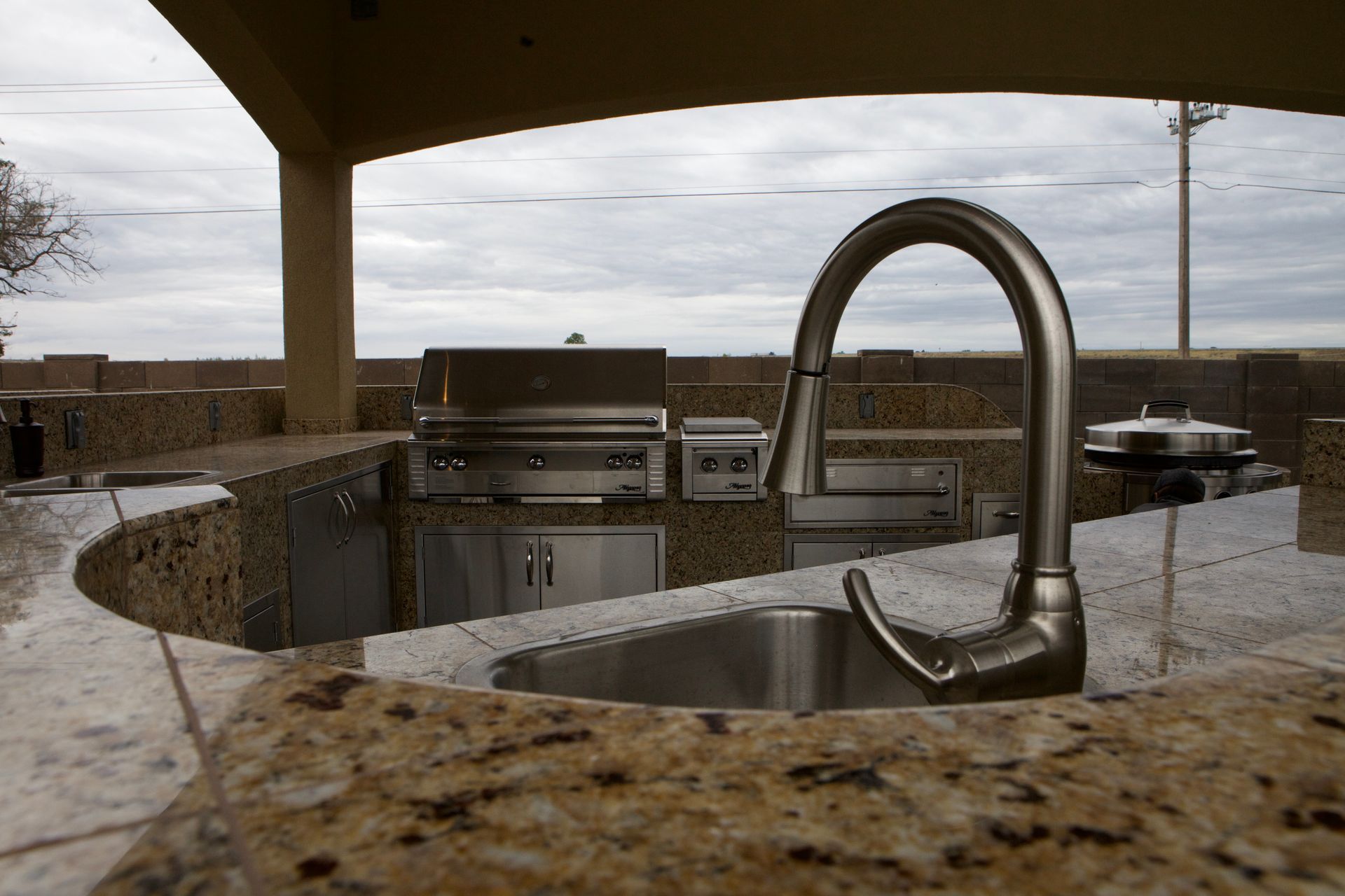 A kitchen with a stainless steel sink and a grill