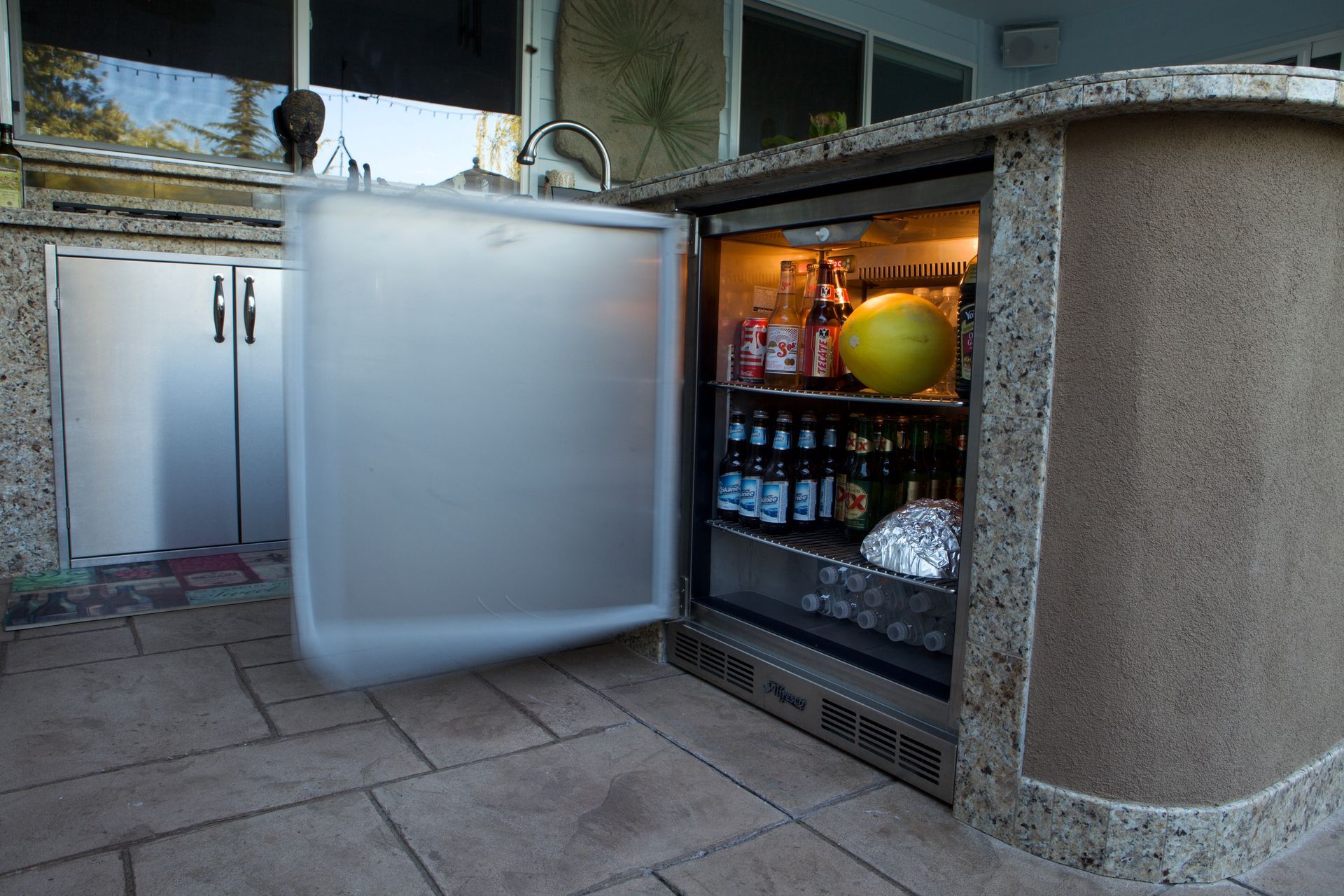 A refrigerator with the door open and bottles inside