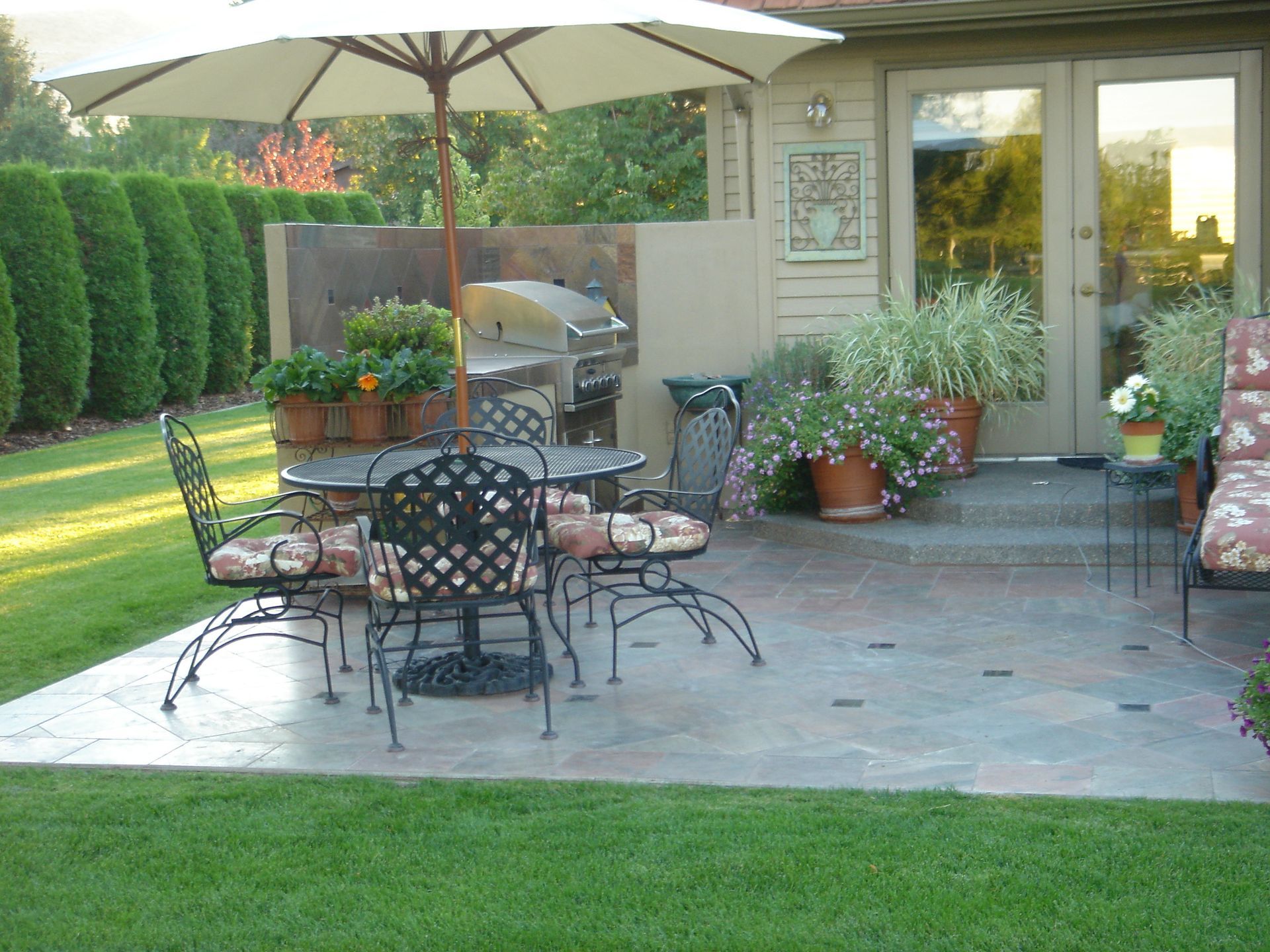 A patio with a table and chairs under an umbrella