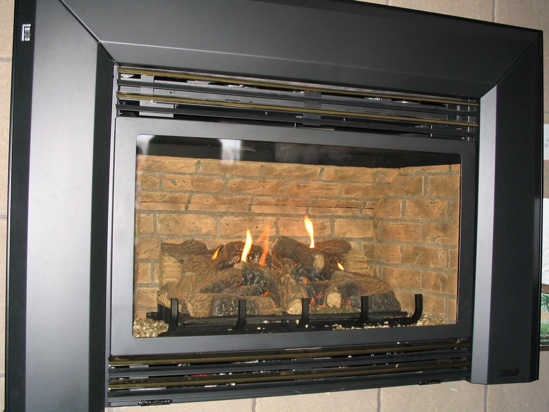 A fireplace with a black frame and a brick wall
