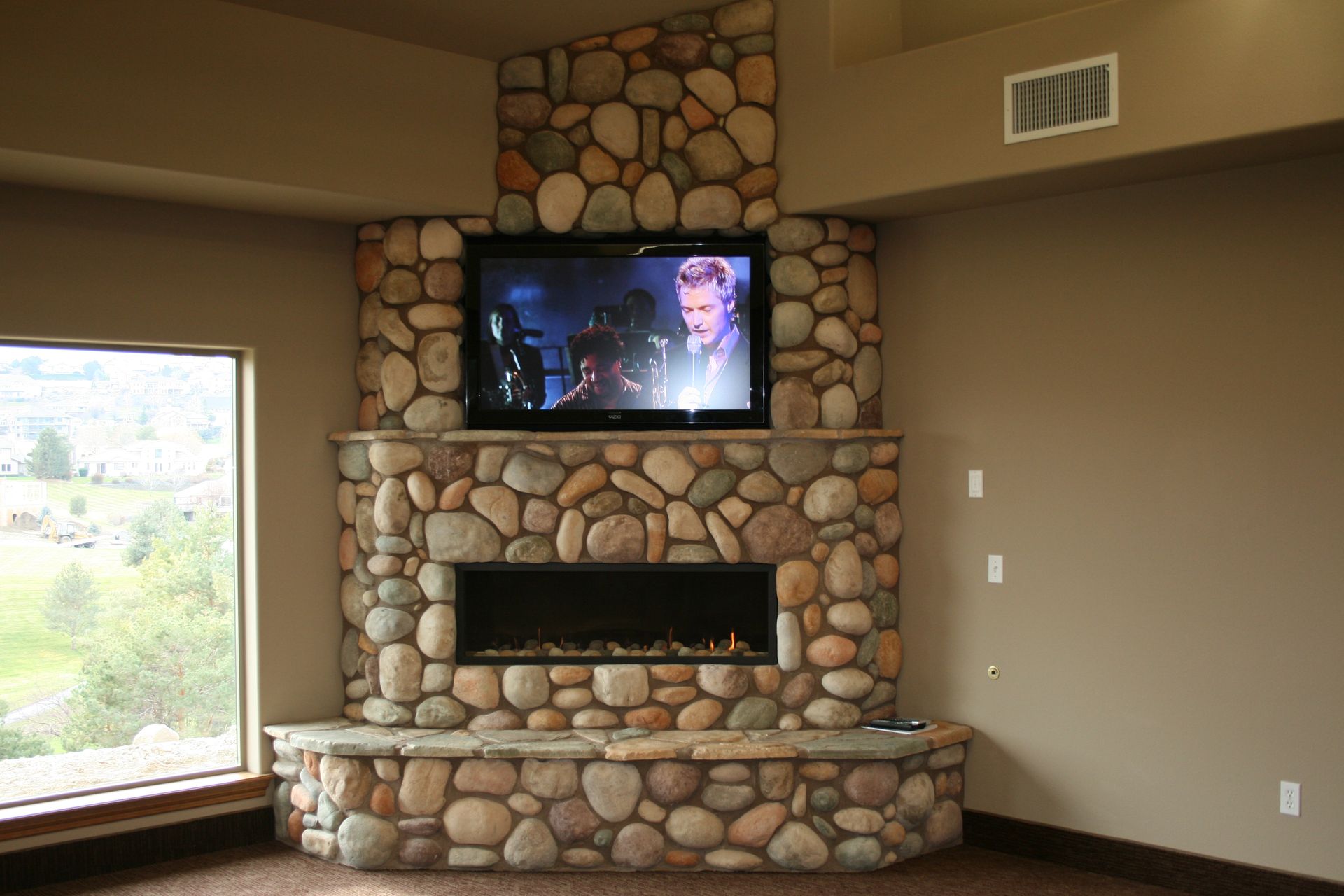 A stone fireplace with a flat screen tv above it