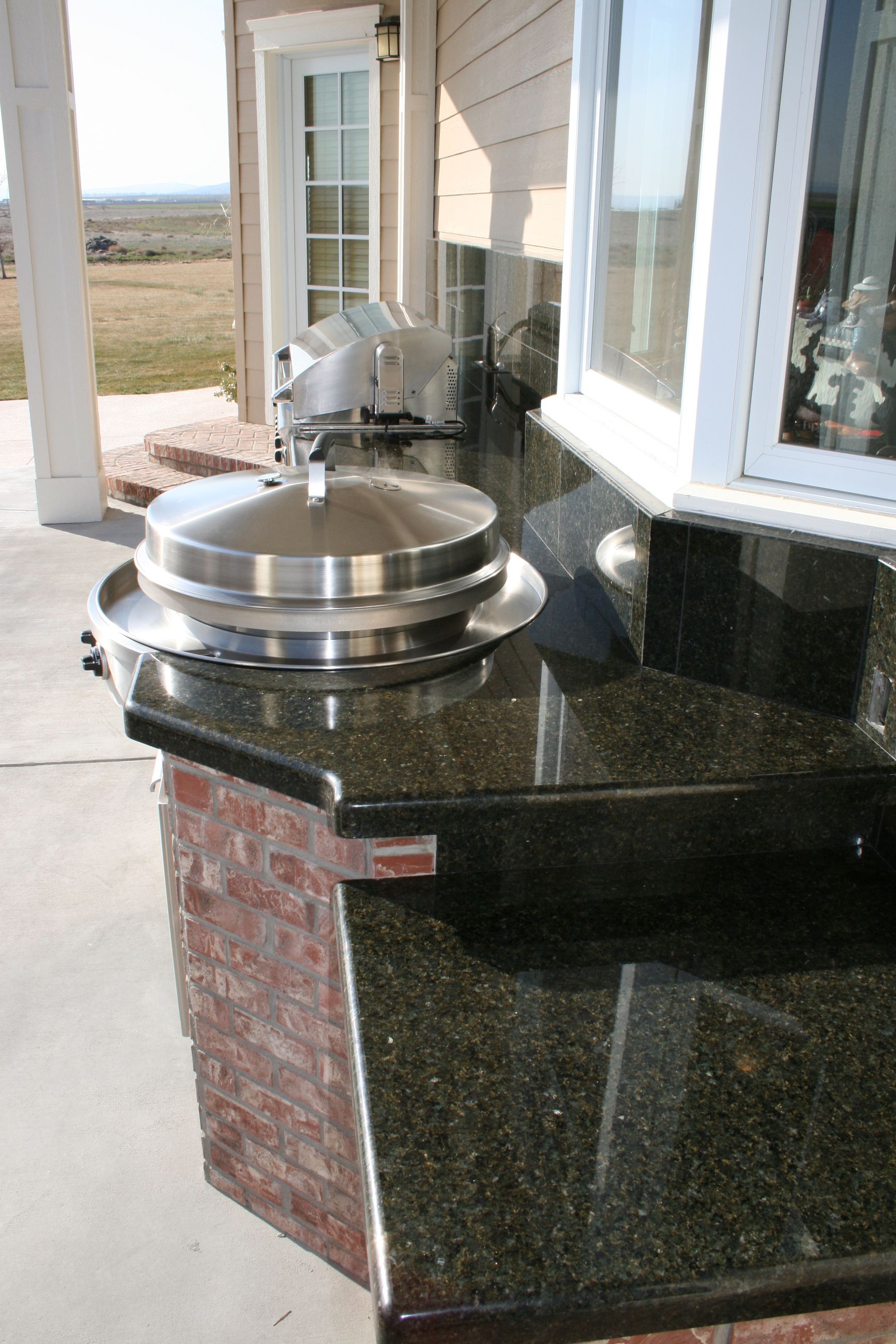 A stainless steel grill is sitting on top of a granite counter.