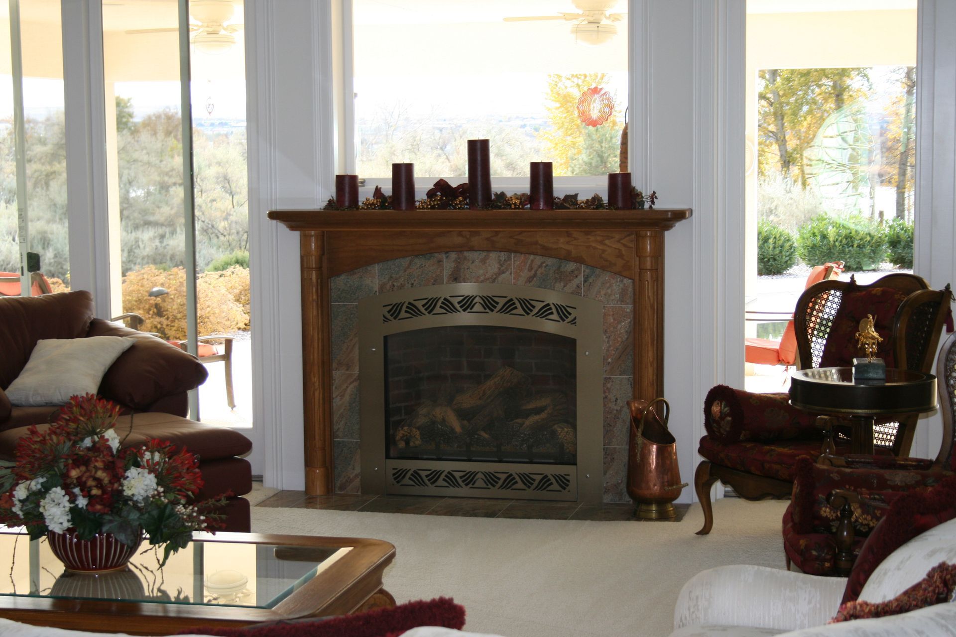 A living room with a fireplace and a vase of flowers
