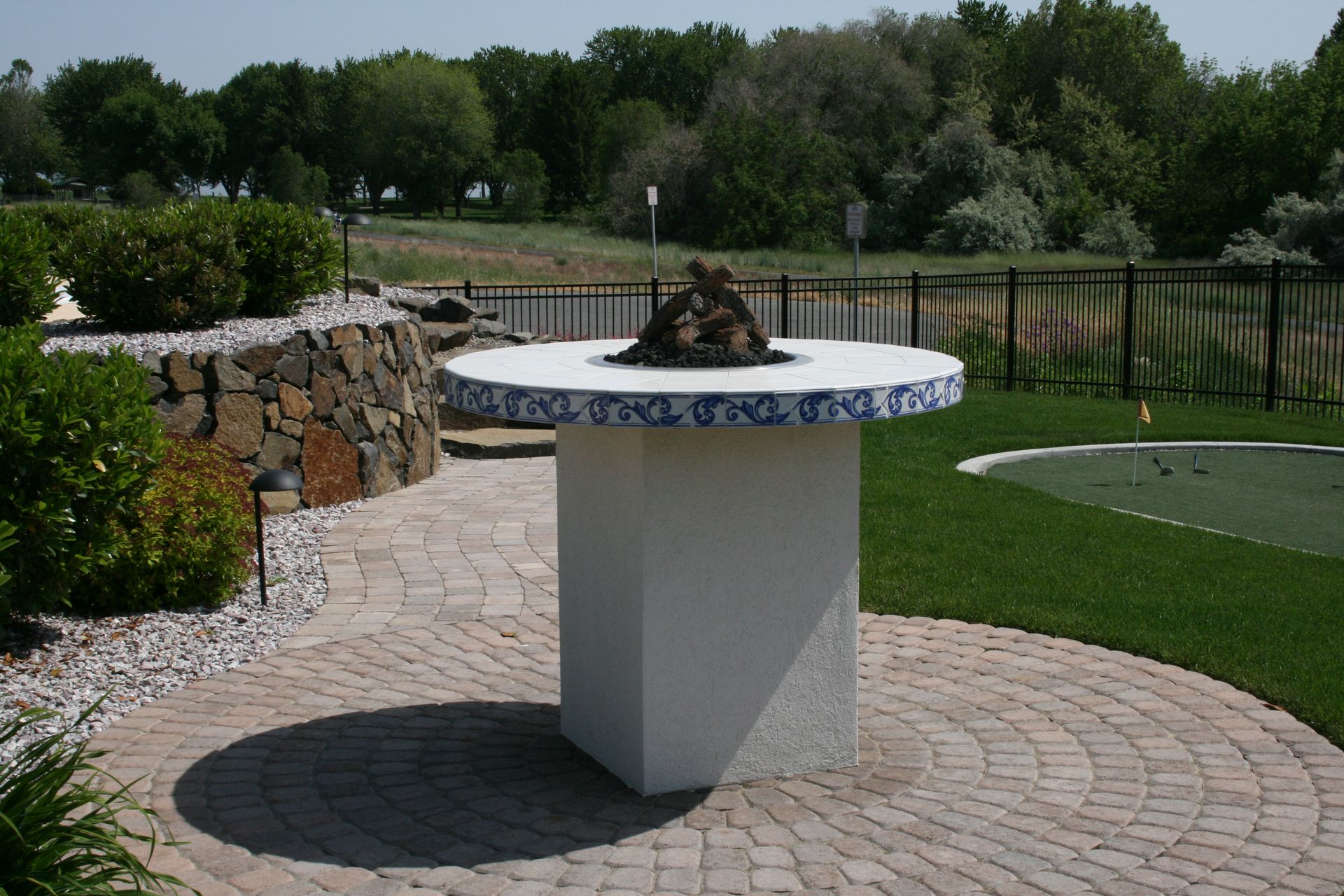 A brick patio with a fire pit in the middle