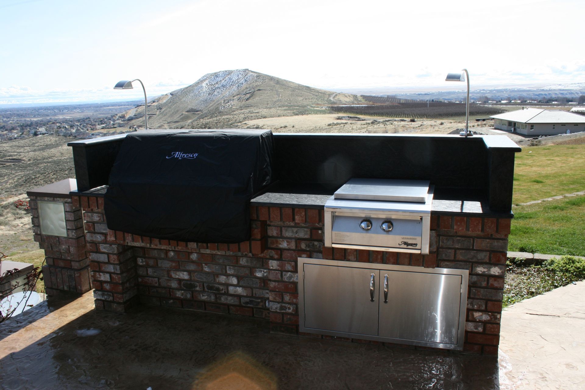 An outdoor grill with a black cover on it
