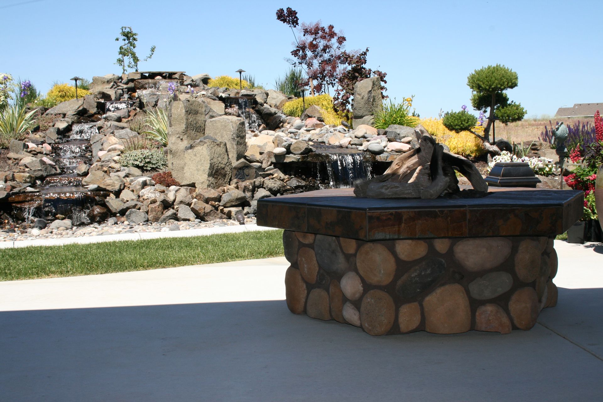 A fire pit with a waterfall in the background