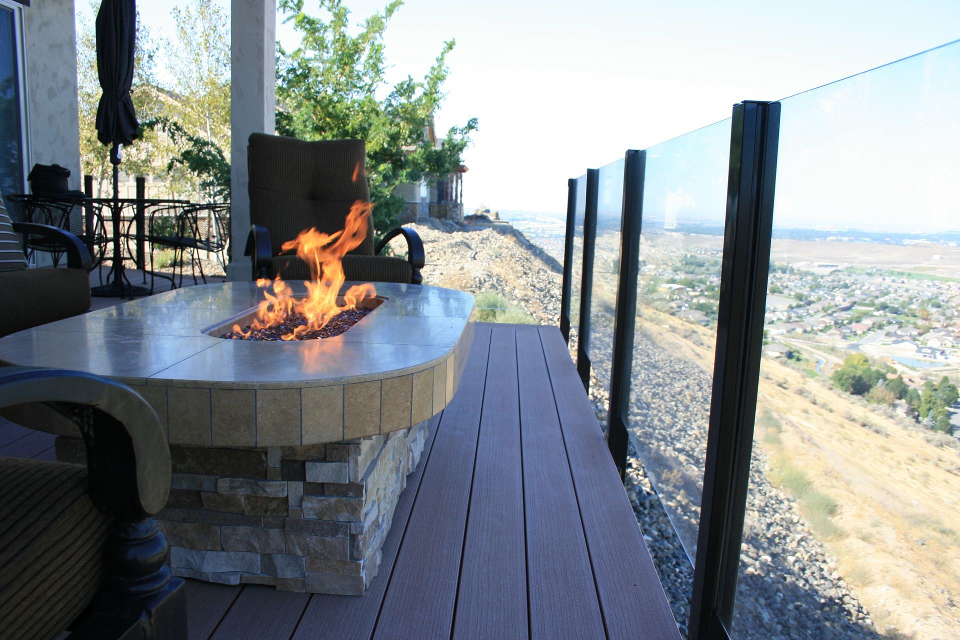 A fire pit on a deck with a view of a city