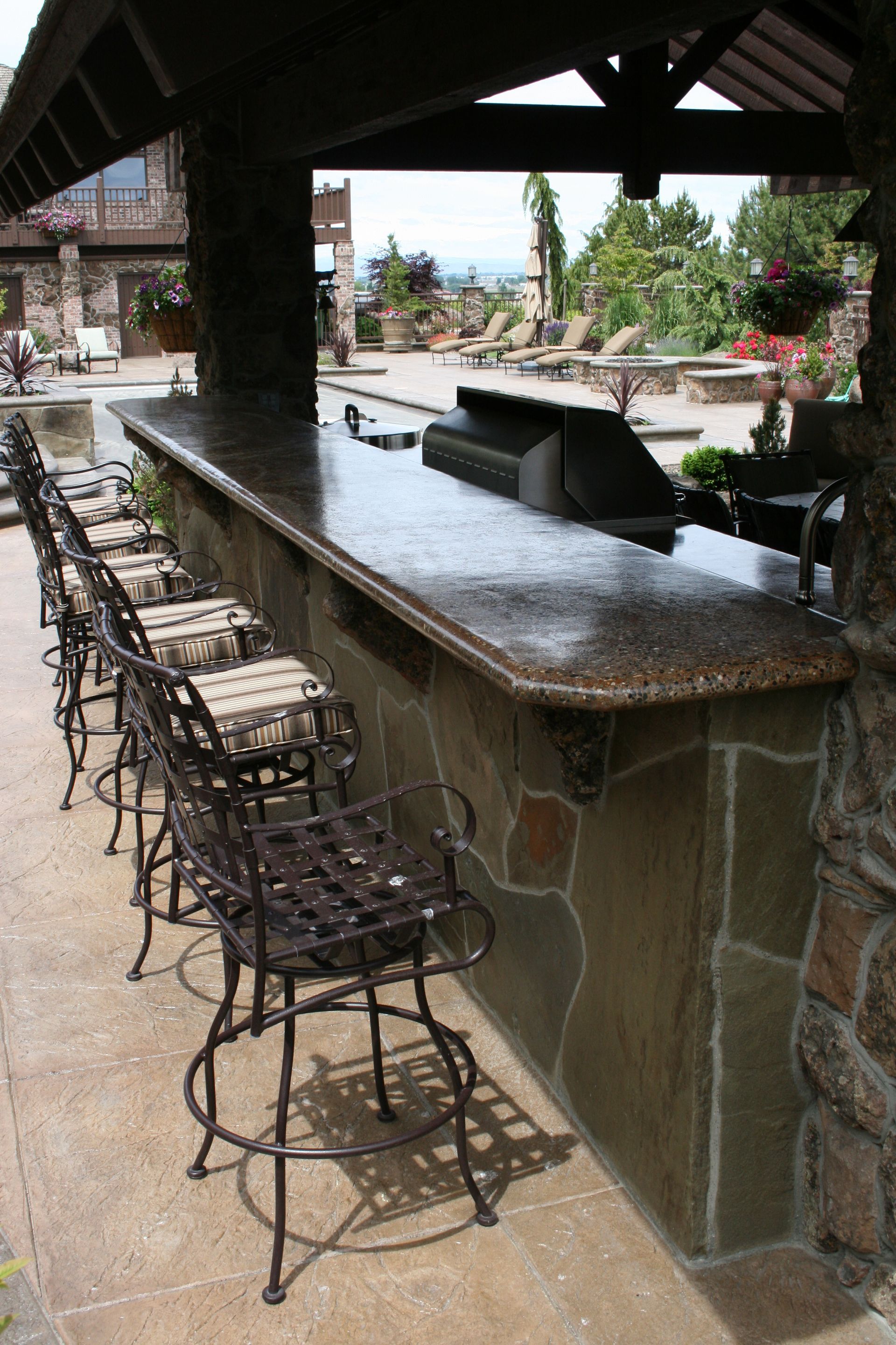 A row of stools are lined up in front of a stone bar