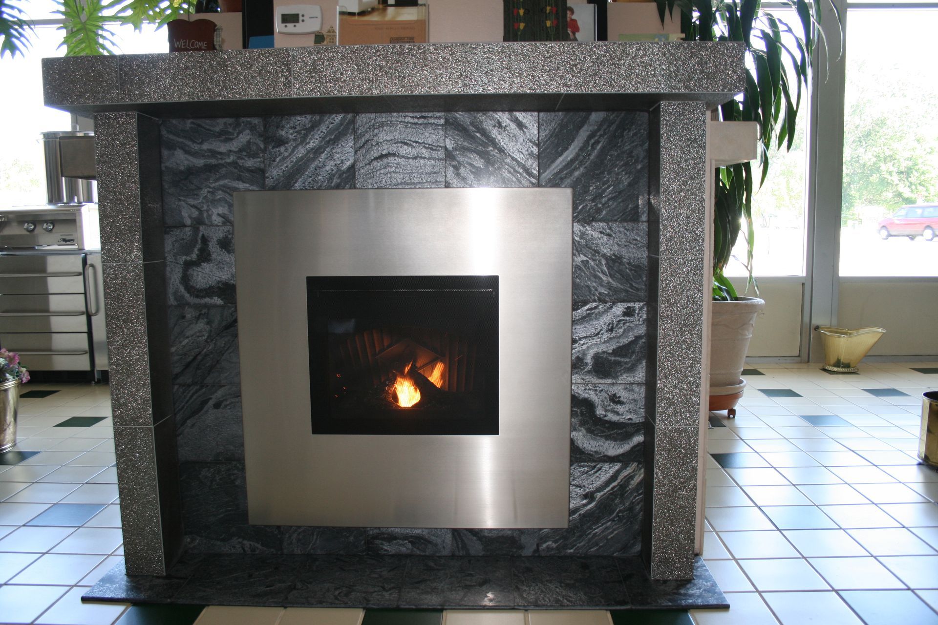 A fireplace with a stainless steel frame surrounding it