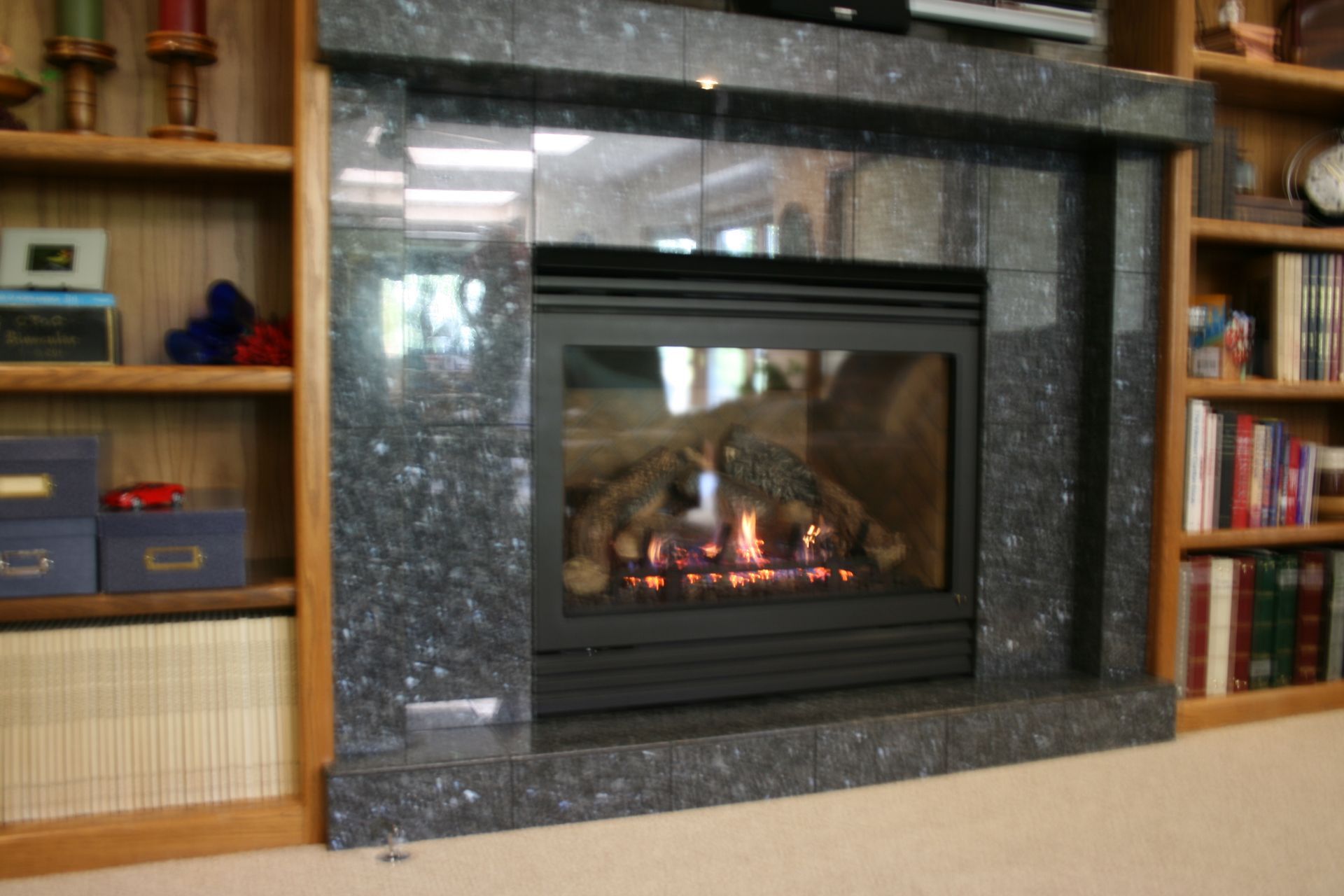 A fireplace in a living room surrounded by bookshelves