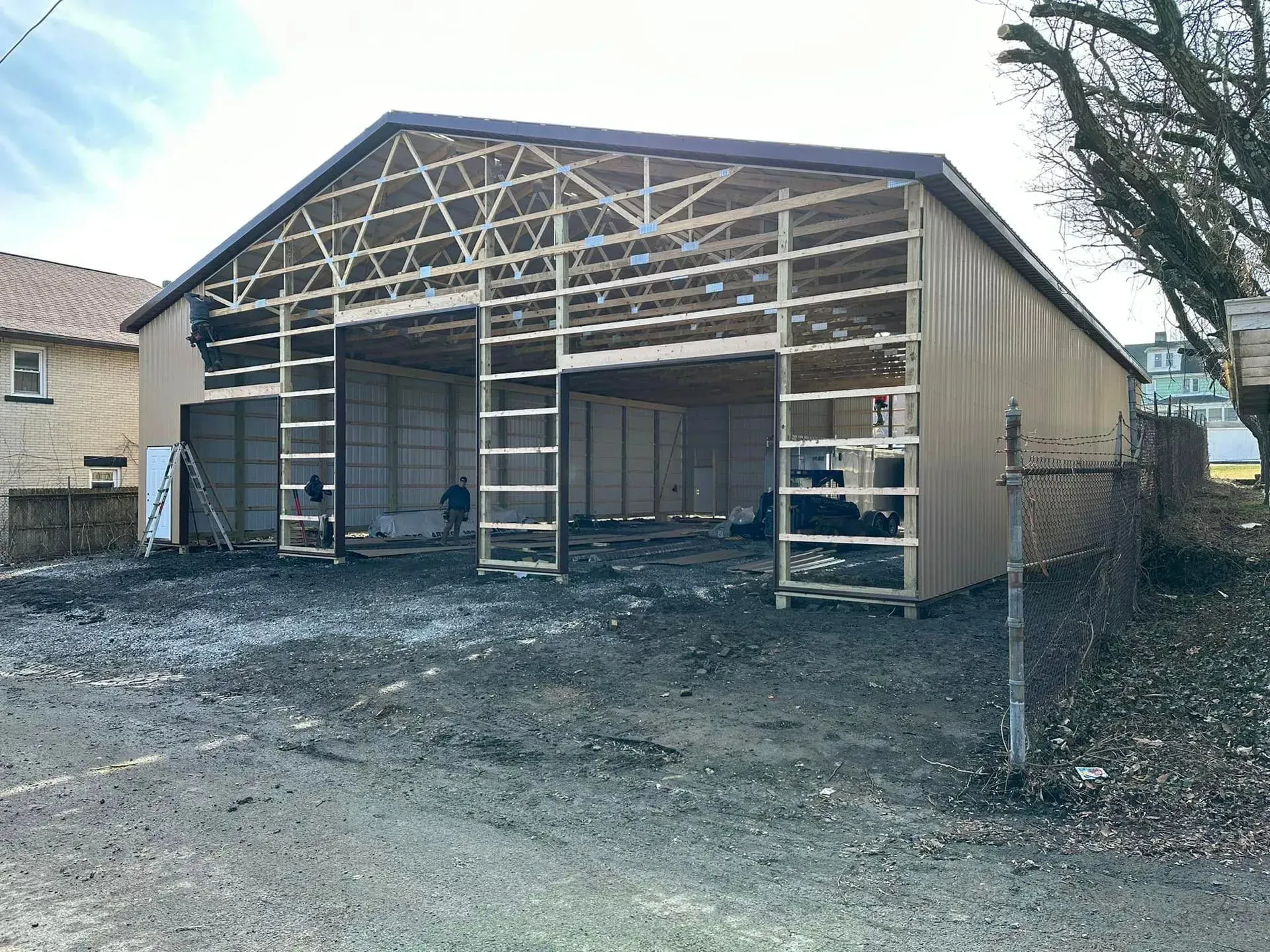 A large building is being built in the middle of a dirt field.