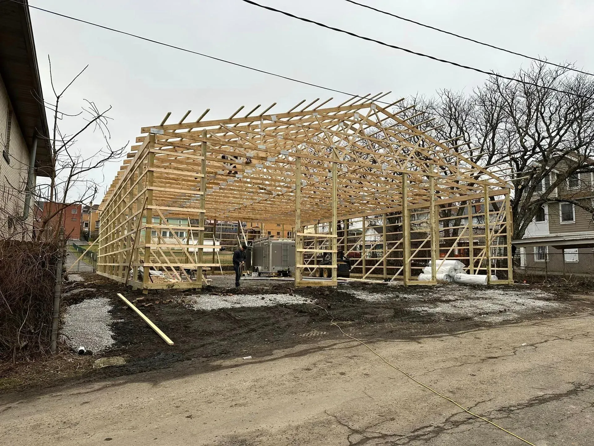 A large wooden structure is being built in the middle of a dirt road.