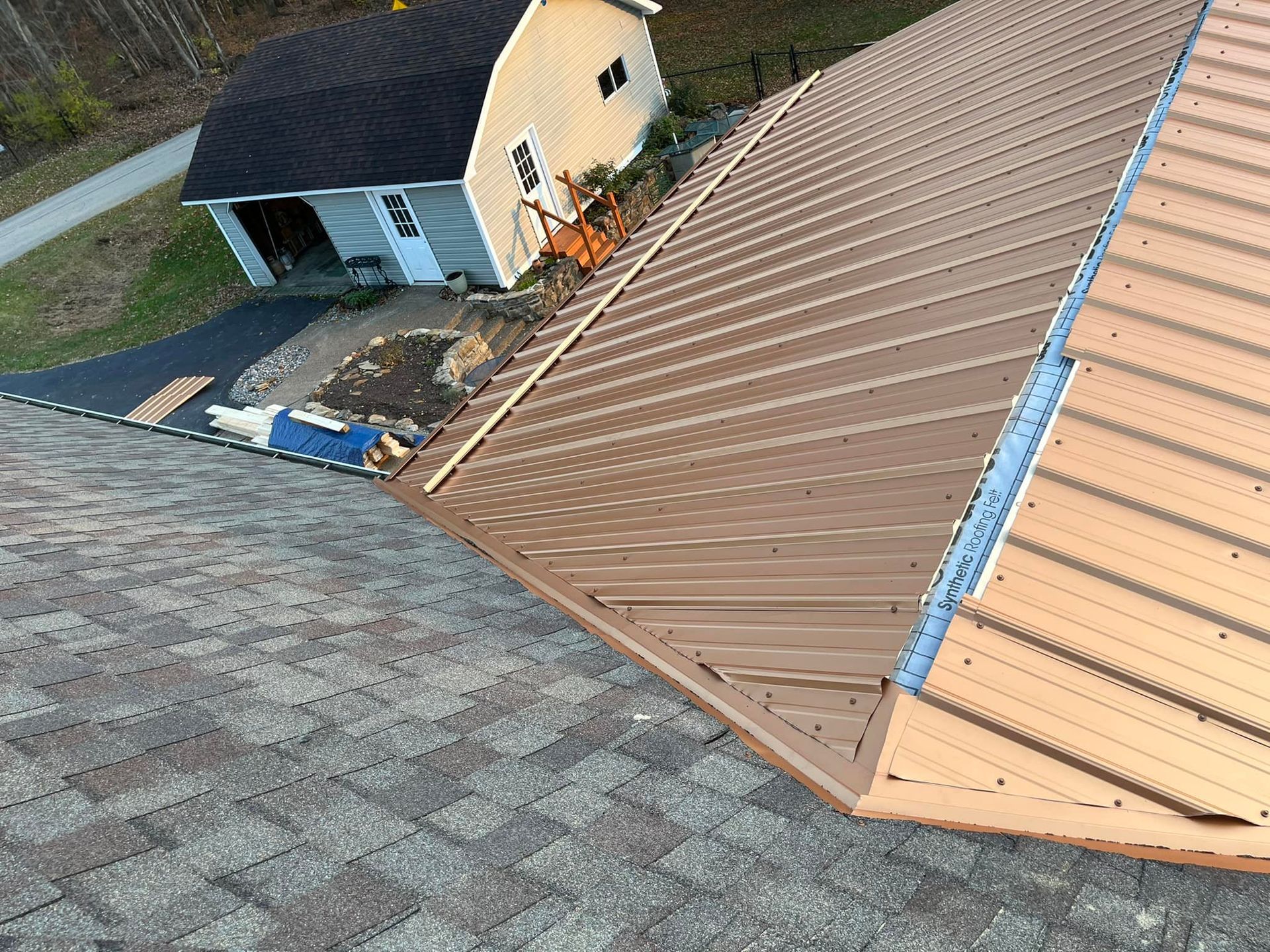 An aerial view of a metal roof being installed on a house.