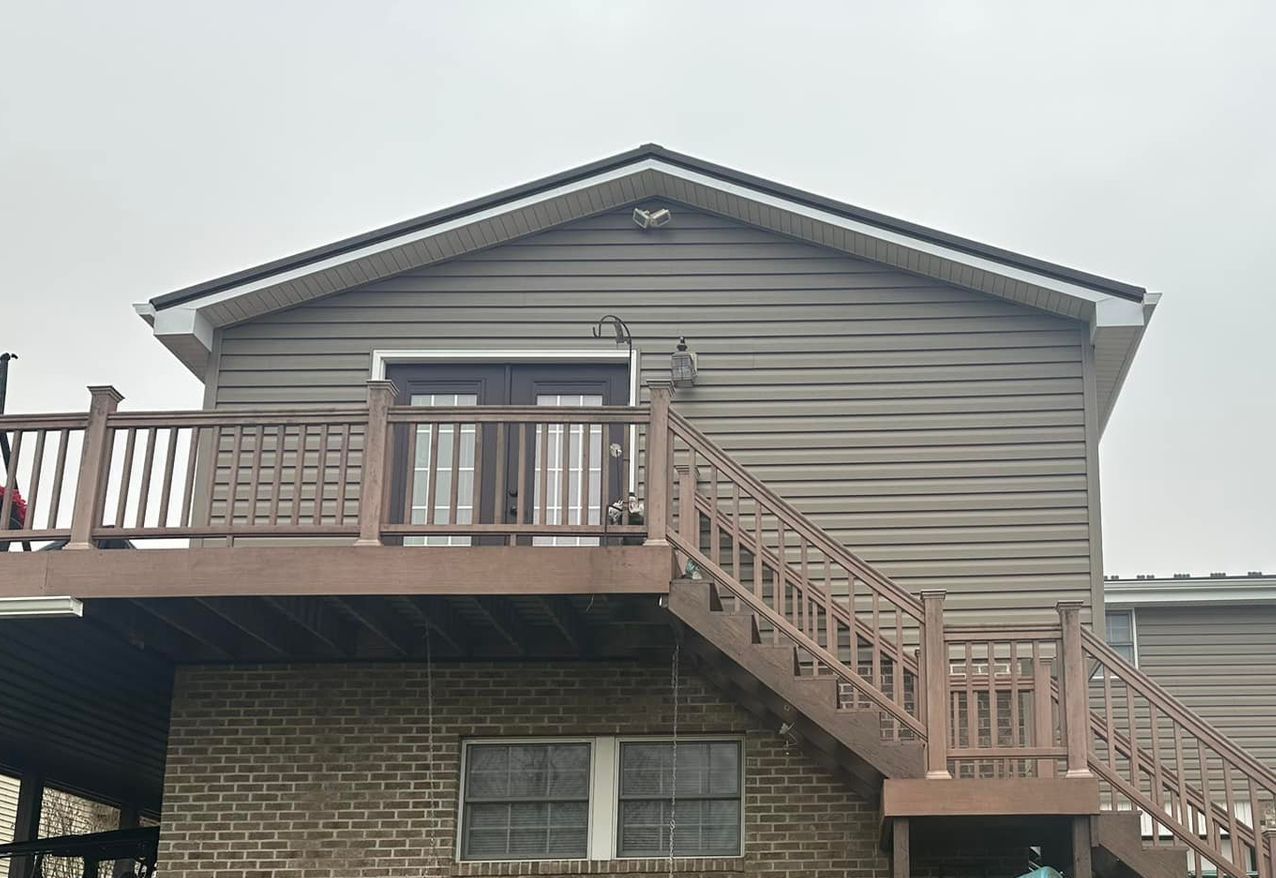 A house with a deck and stairs on the side of it.