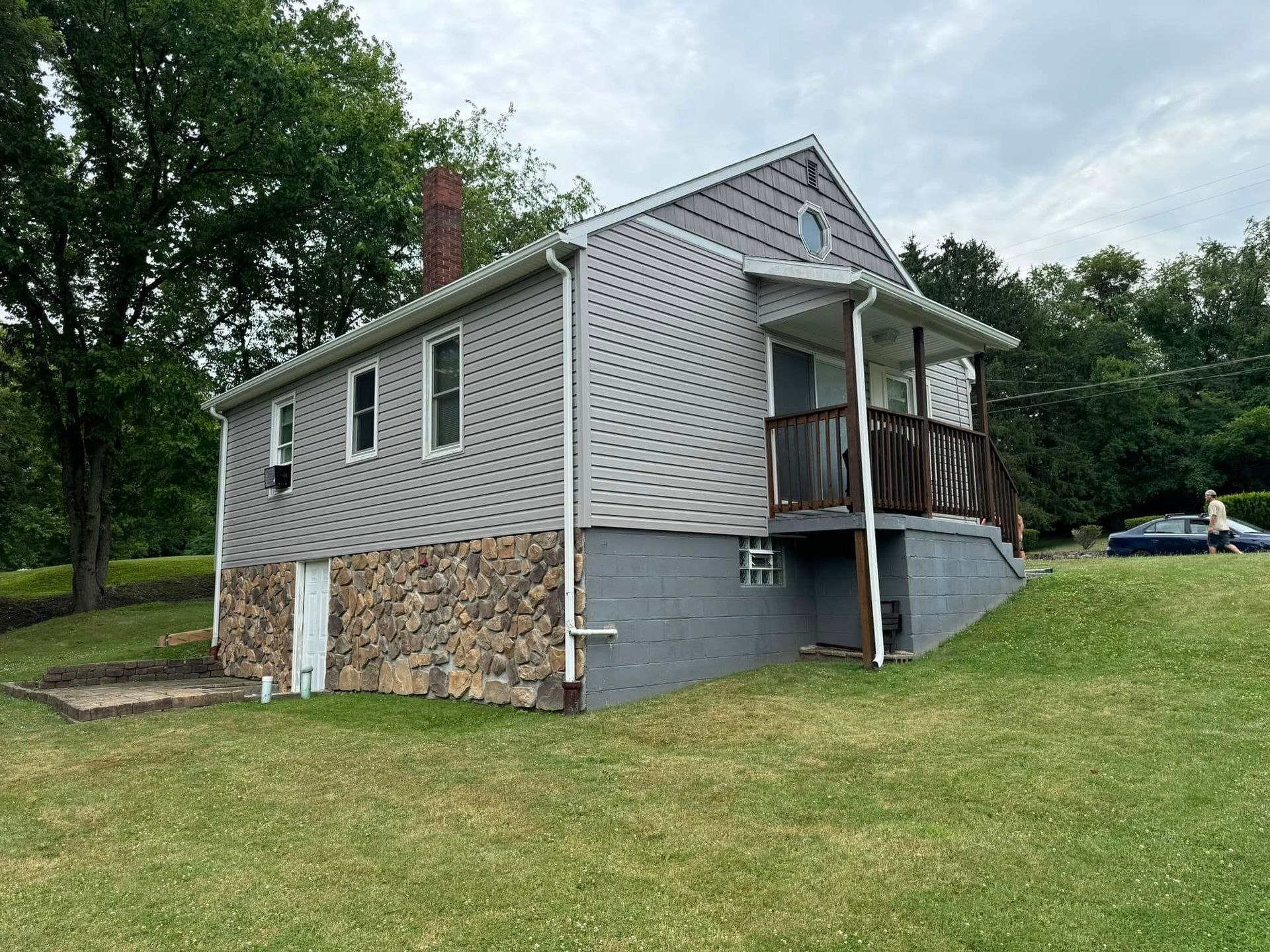 A house with a porch and a car parked in front of it.