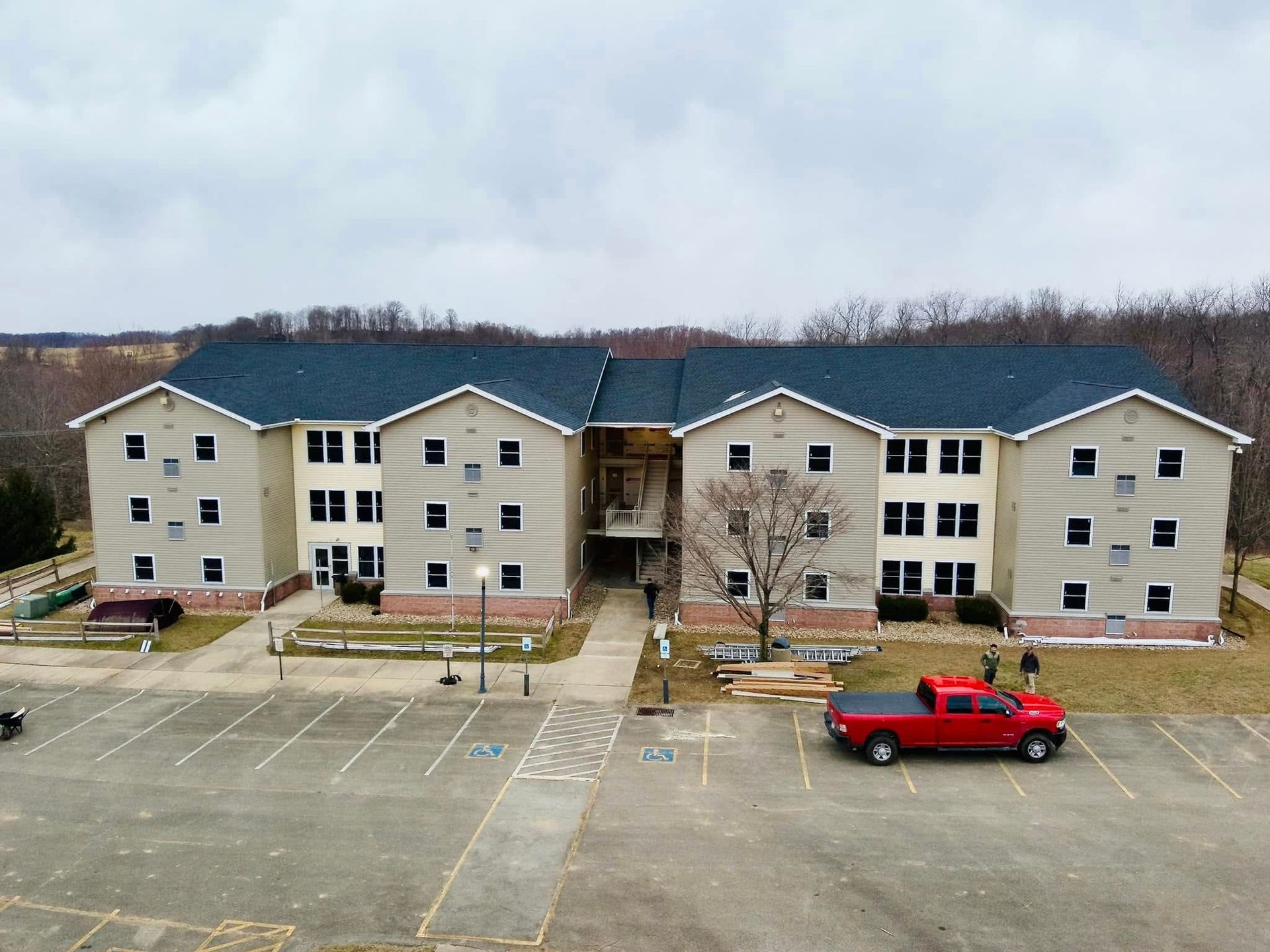 A large apartment building with a red truck parked in front of it
