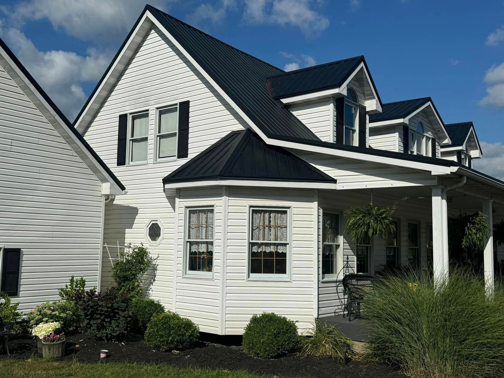 A white house with a black roof and black shutters