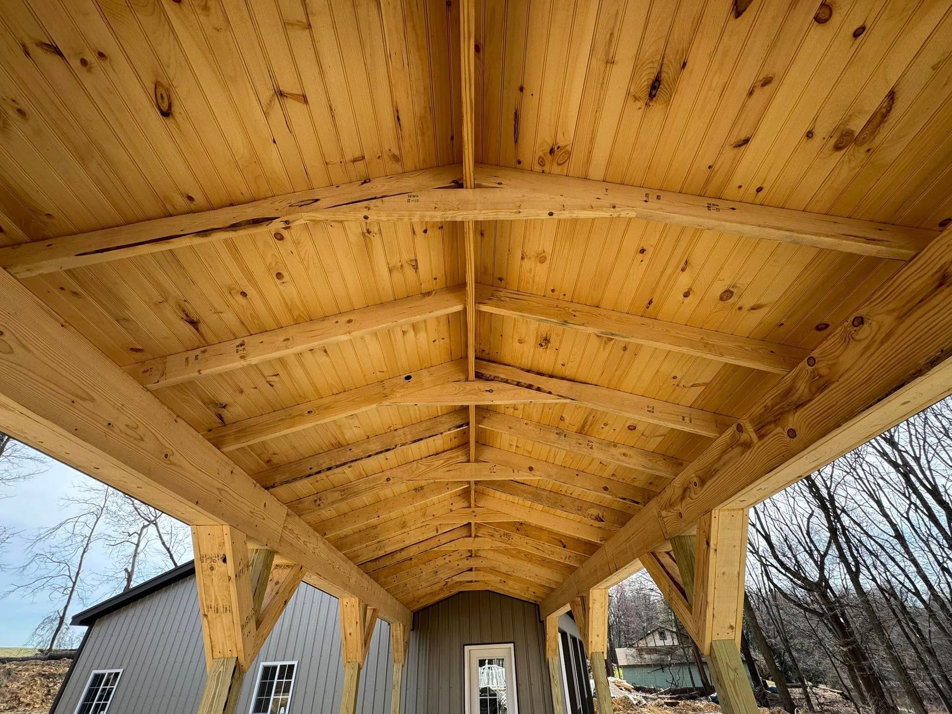 The ceiling of a wooden structure is covered in wood.