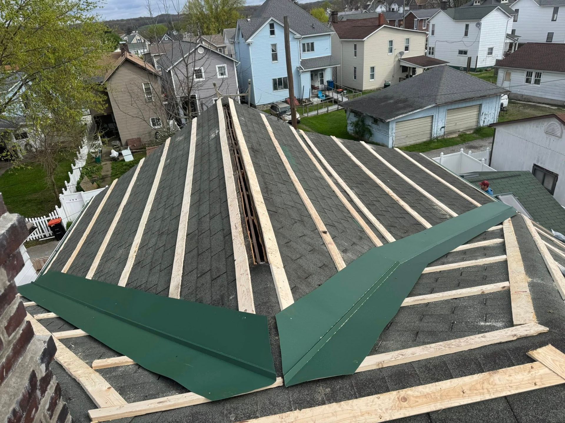 A roof is being built with wooden beams and shingles.