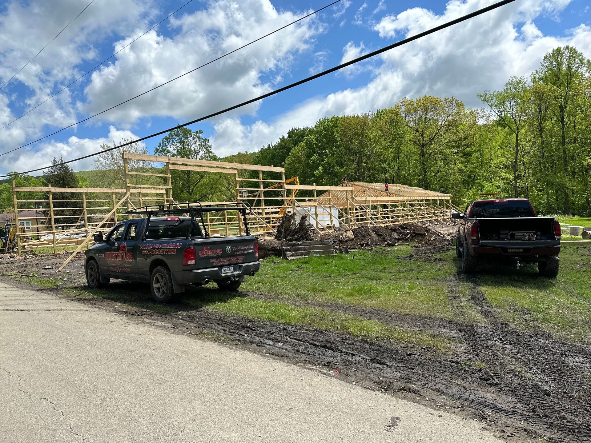 Two trucks are parked in front of a building under construction.
