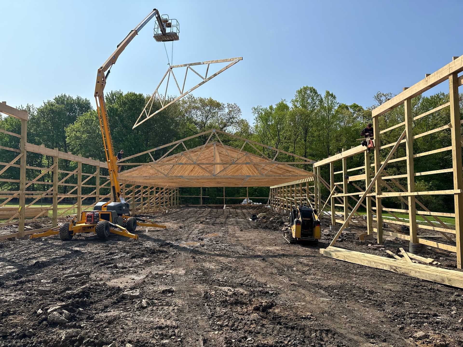 A large building is being built in the middle of a dirt field.
