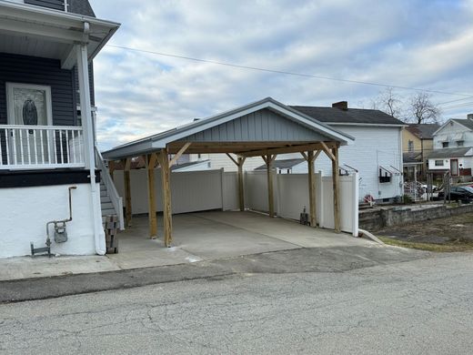 There is a carport in front of a house.