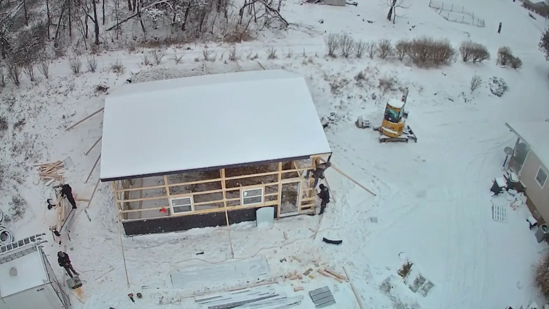 An aerial view of a house being built in the snow.