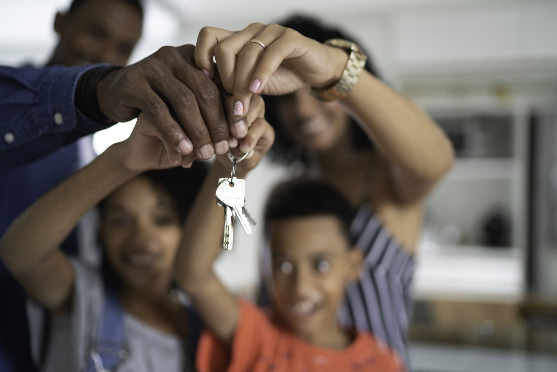 a family of four holding up keys