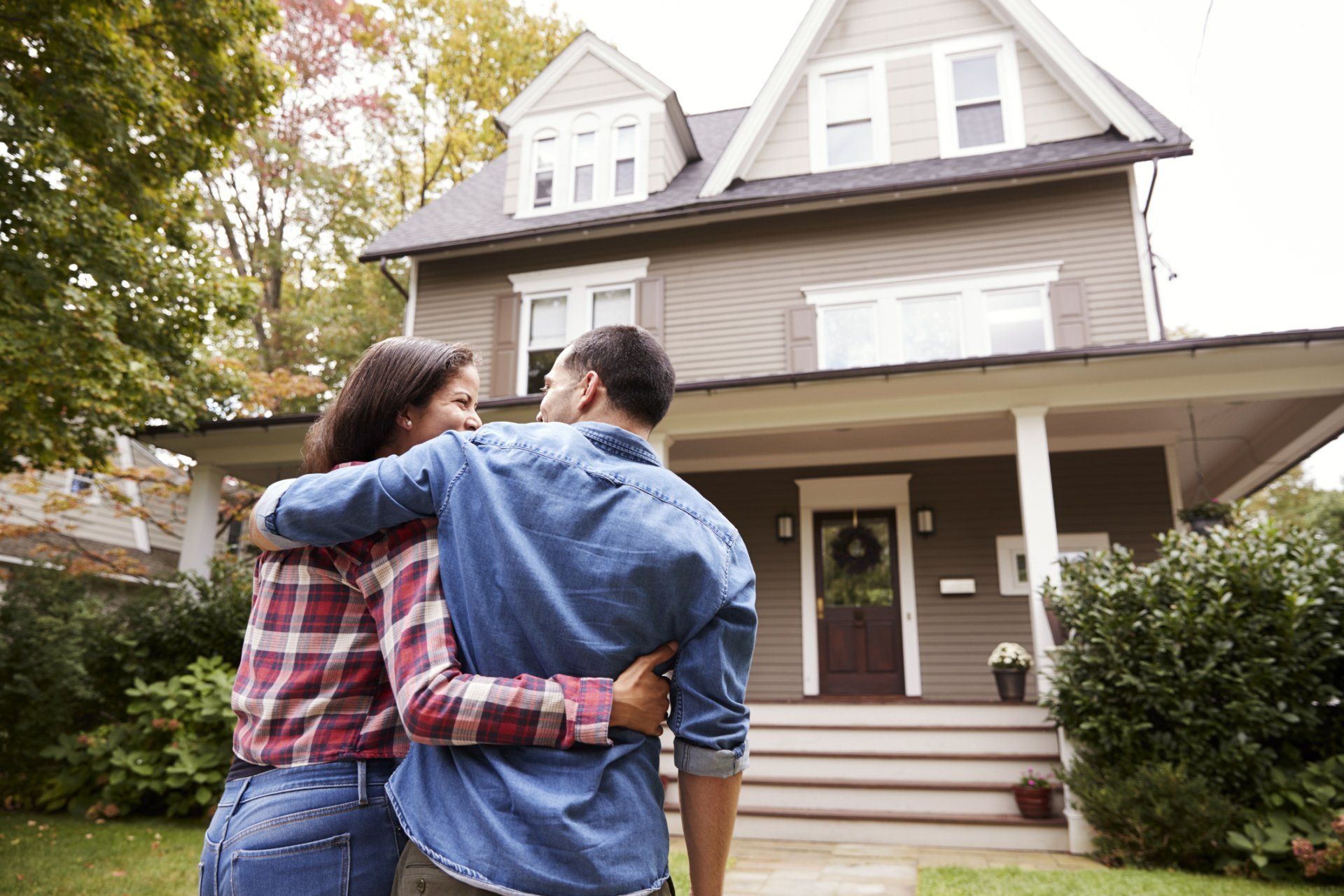 image of woman and man hugging in front of their home