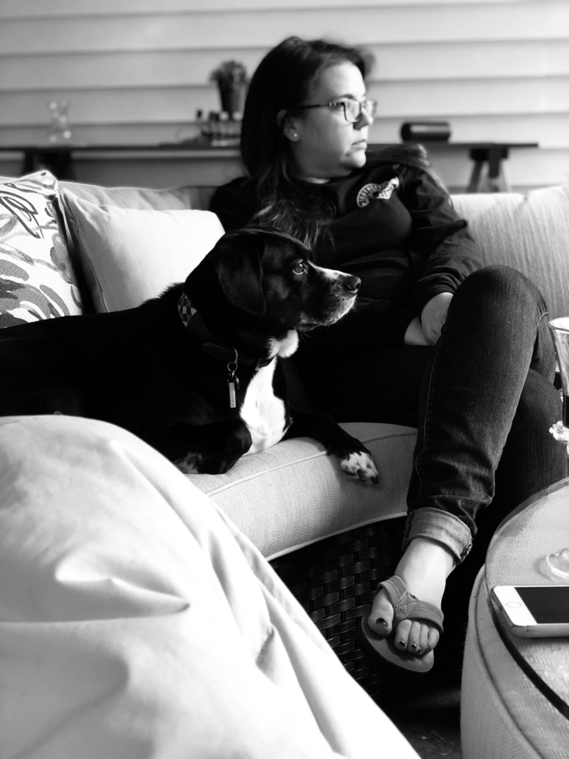 A woman is sitting on a couch with a dog