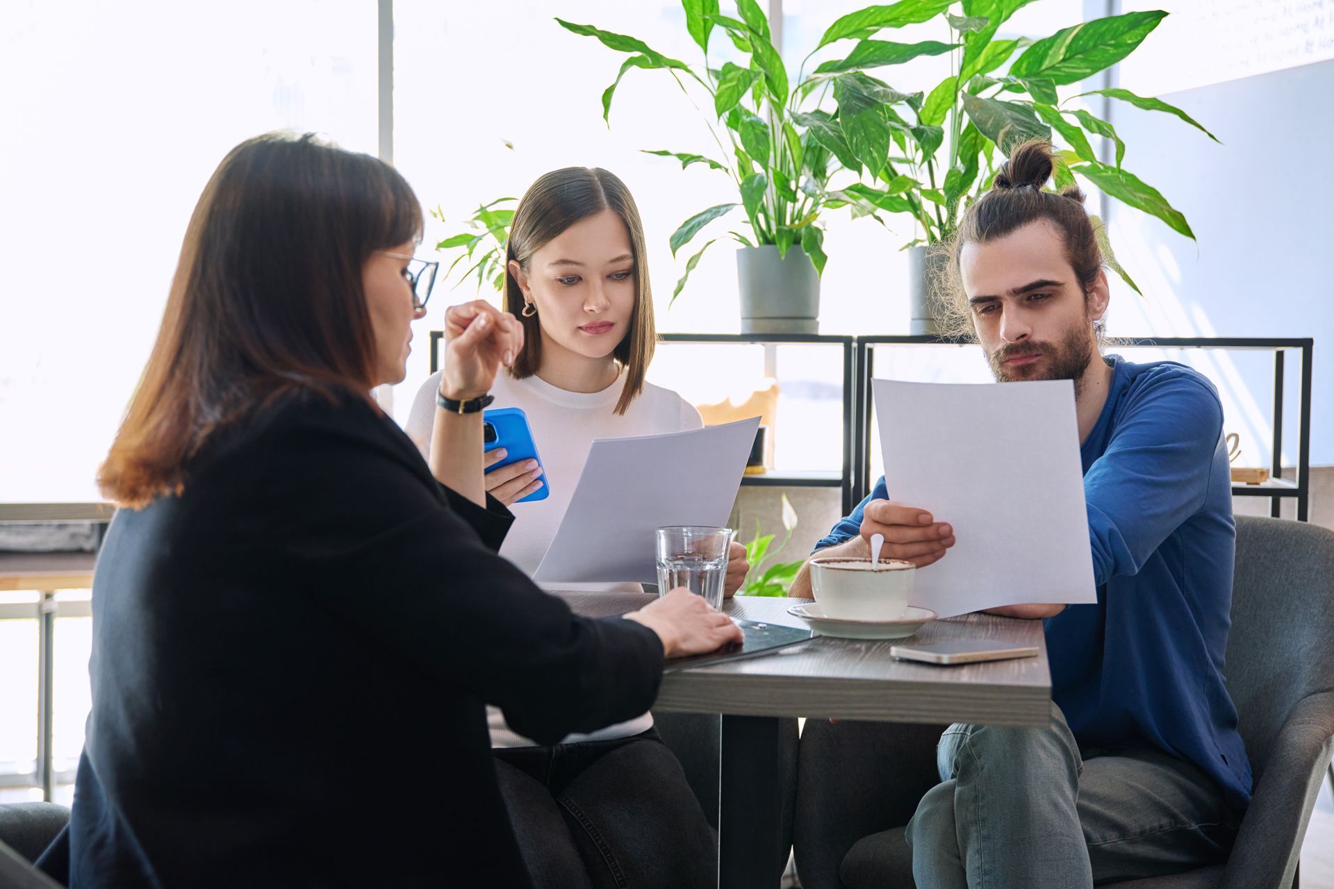 Three people at a table reviewing documents. 