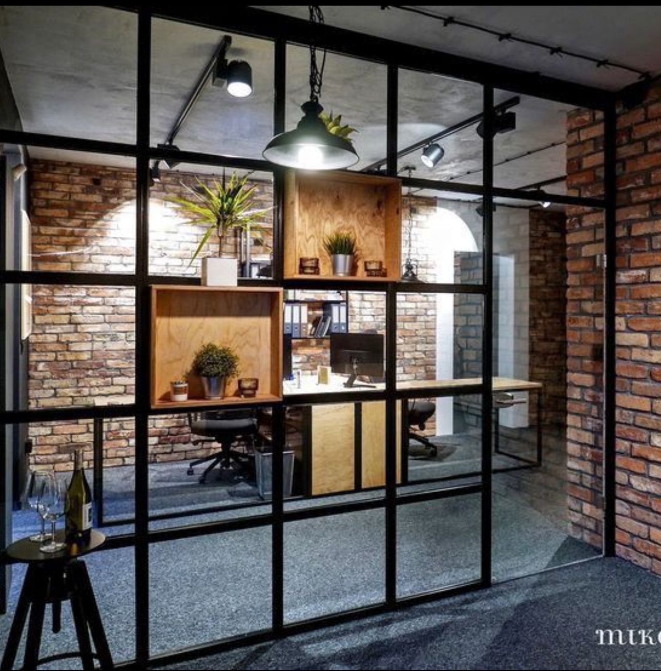 A room with a glass wall and a brick wall