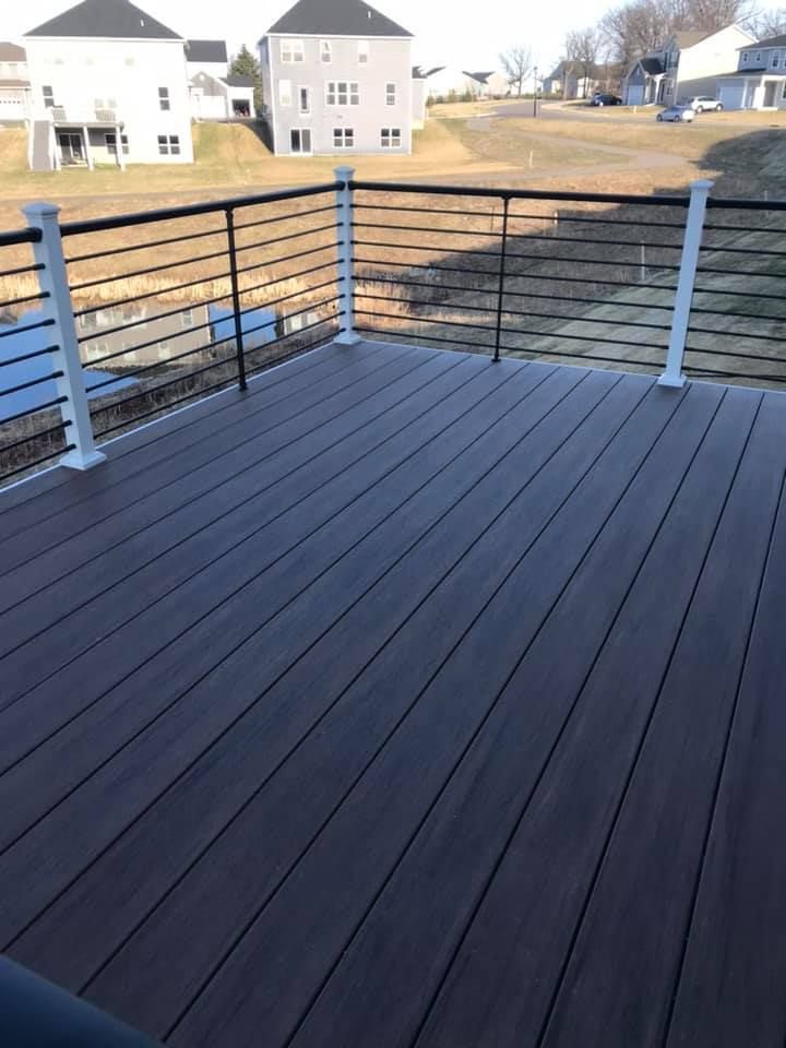 A deck with a railing overlooking a body of water