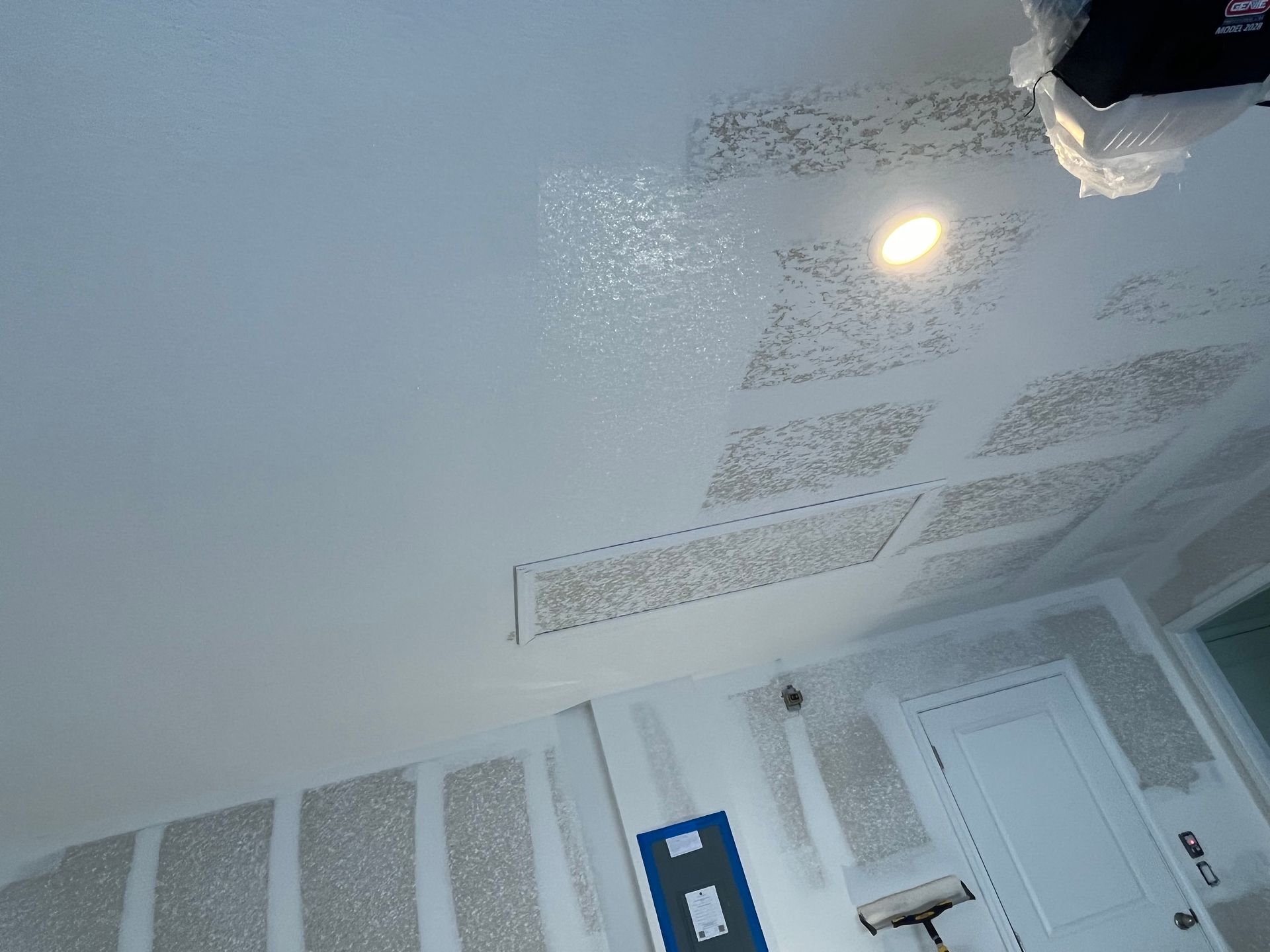 Gloved hands apply white plaster to a wall during home repair, with tools on a table.