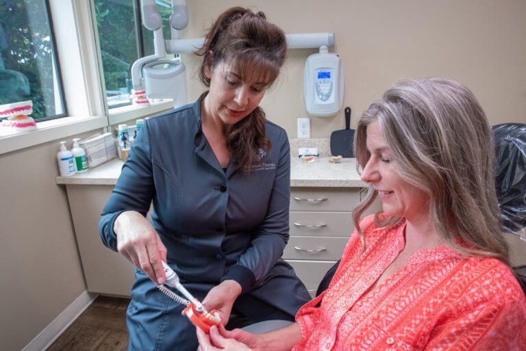 dentist showing patient new tooth brush after teeth cleaning in Lynnwood WA