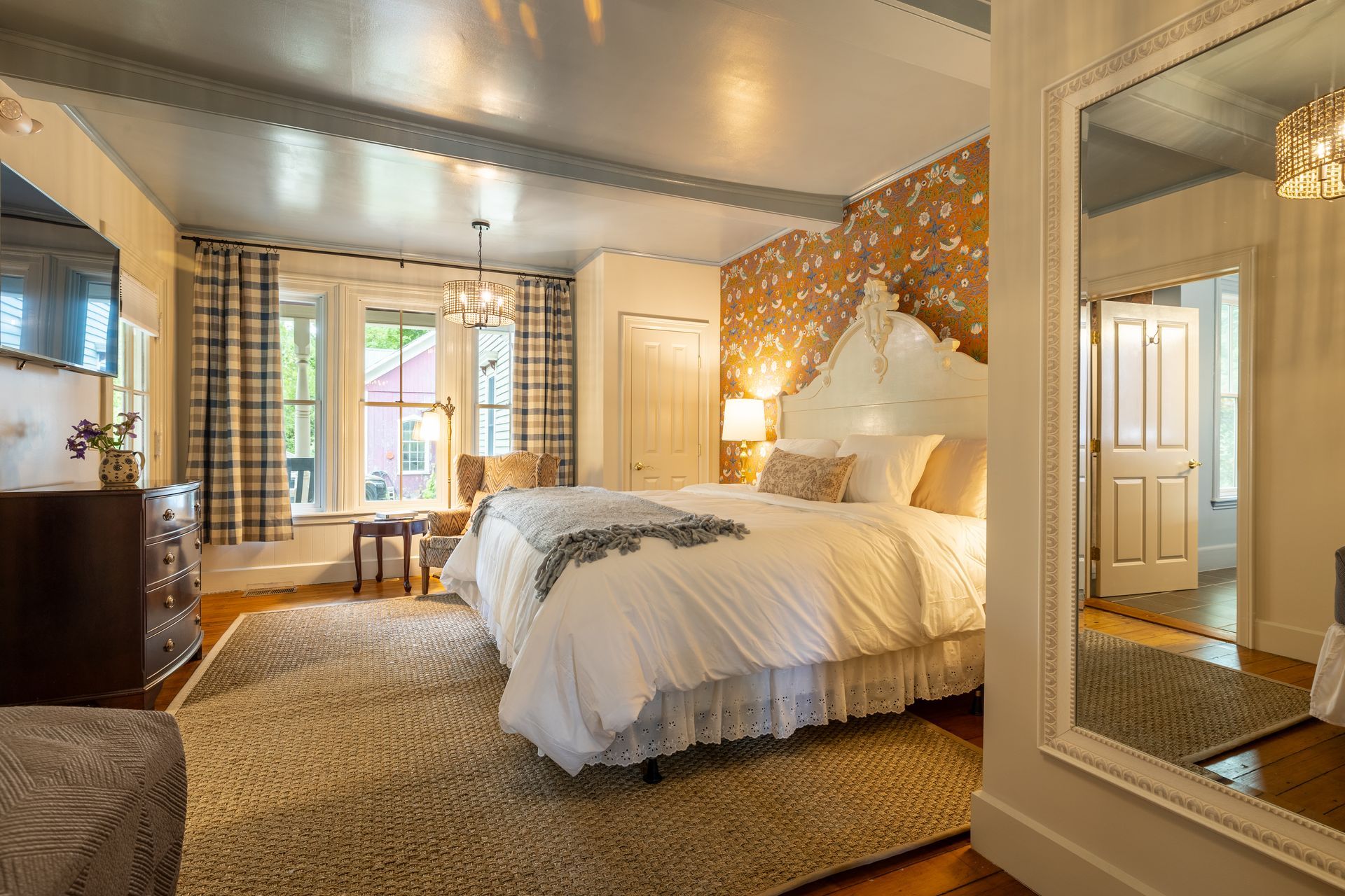 A bedroom with two beds and a large mirror.