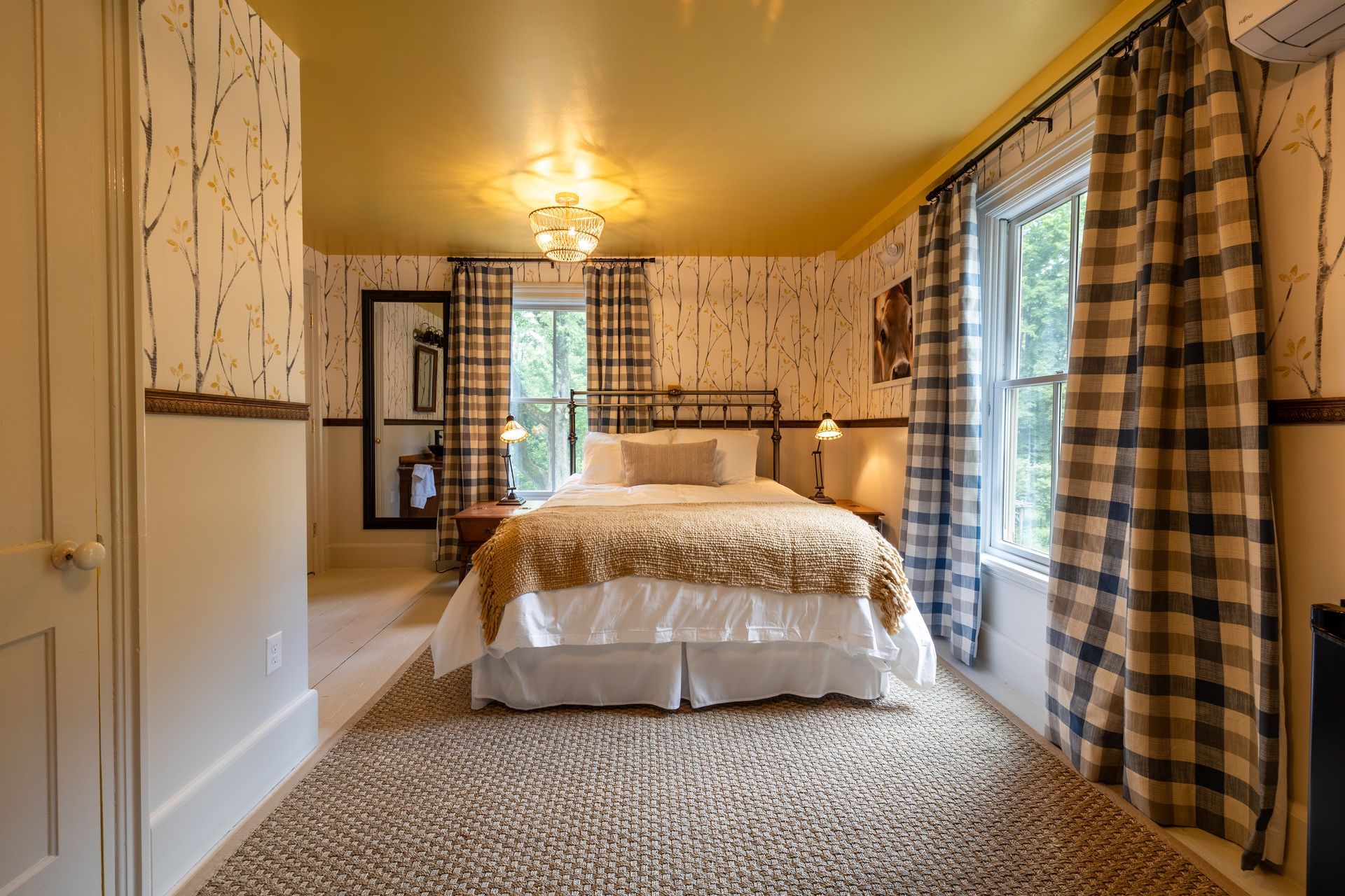 A bedroom with a large bed and plaid curtains