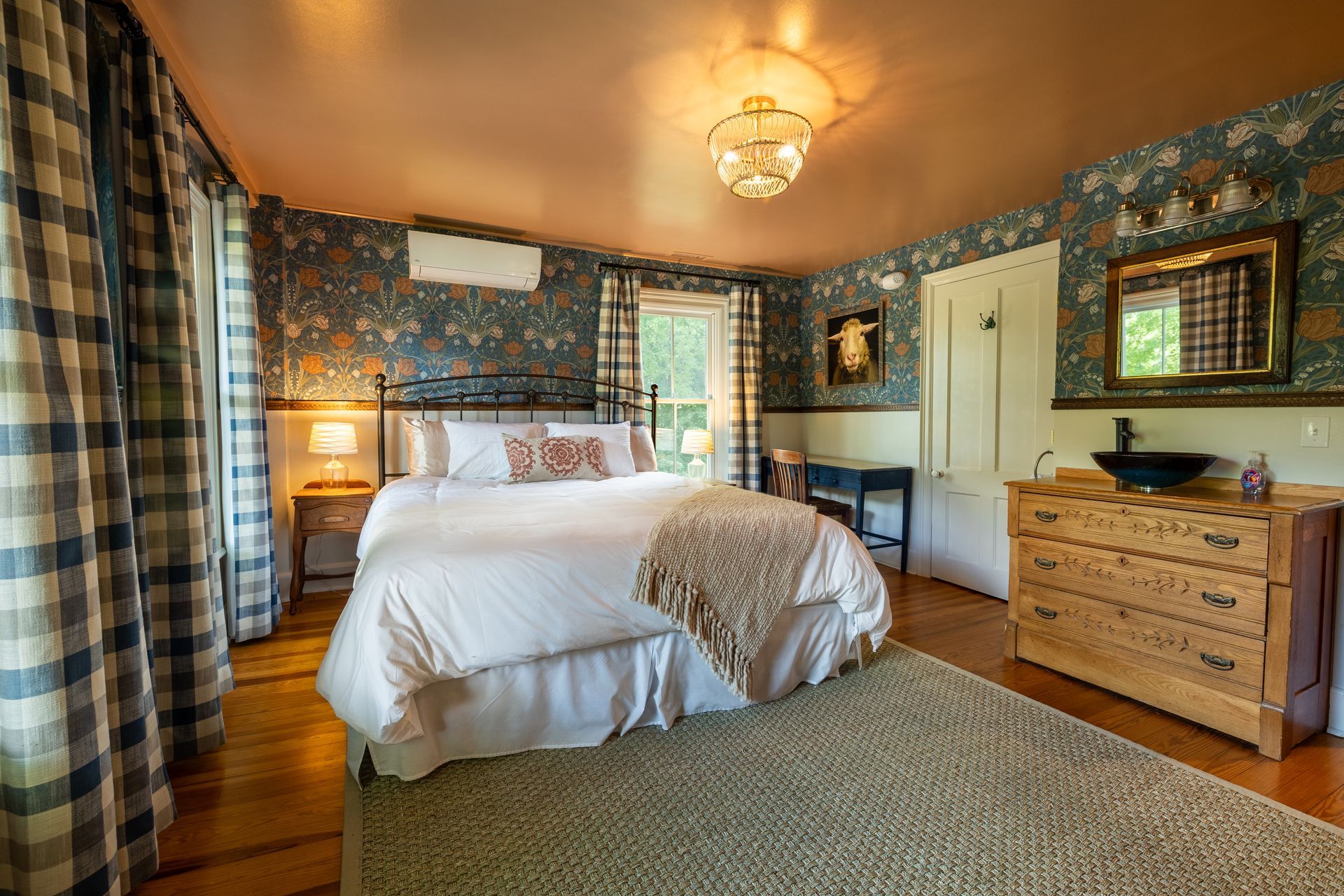 A bedroom with a king size bed , dresser , and sink.