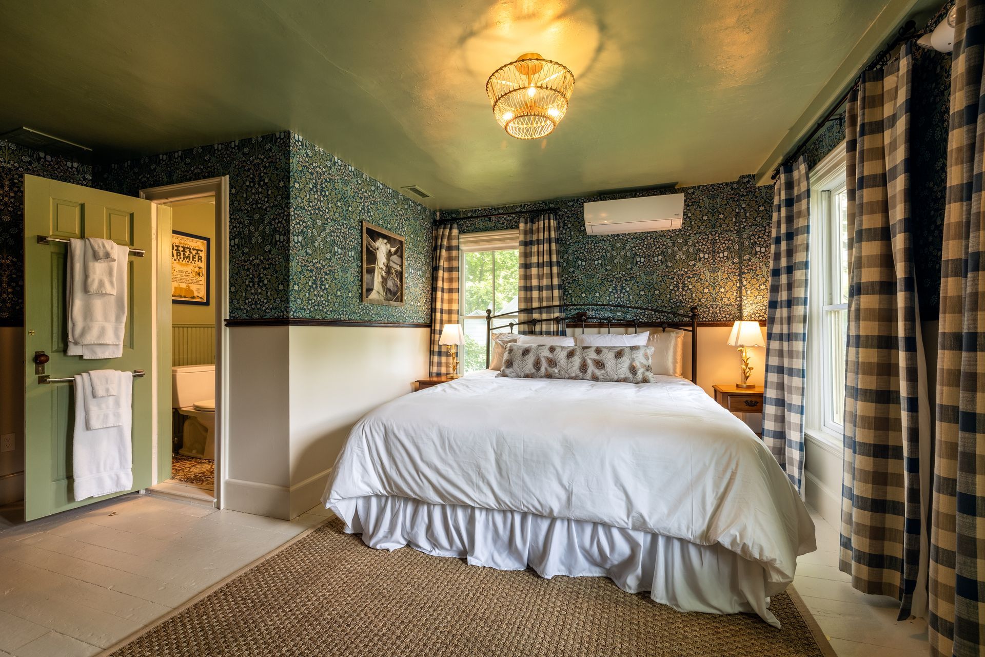 A bedroom with a king size bed and plaid curtains.