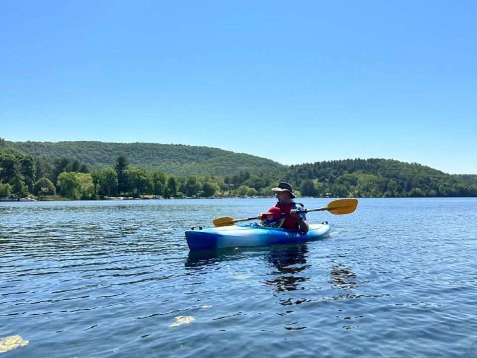 A person is paddling a kayak on a lake.