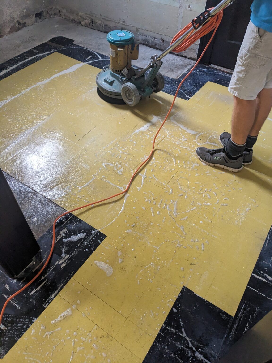 There is a yellow line on the ground in a parking garage.