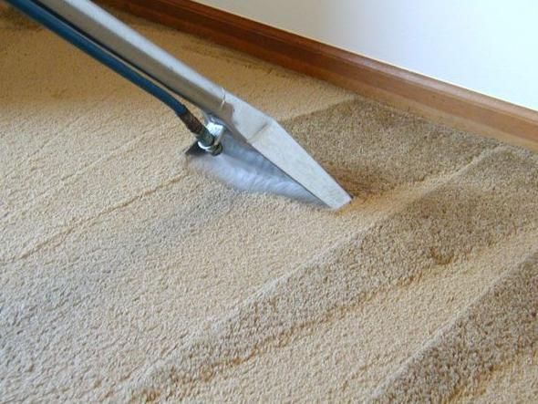 A vacuum cleaner is being used to clean a carpet.