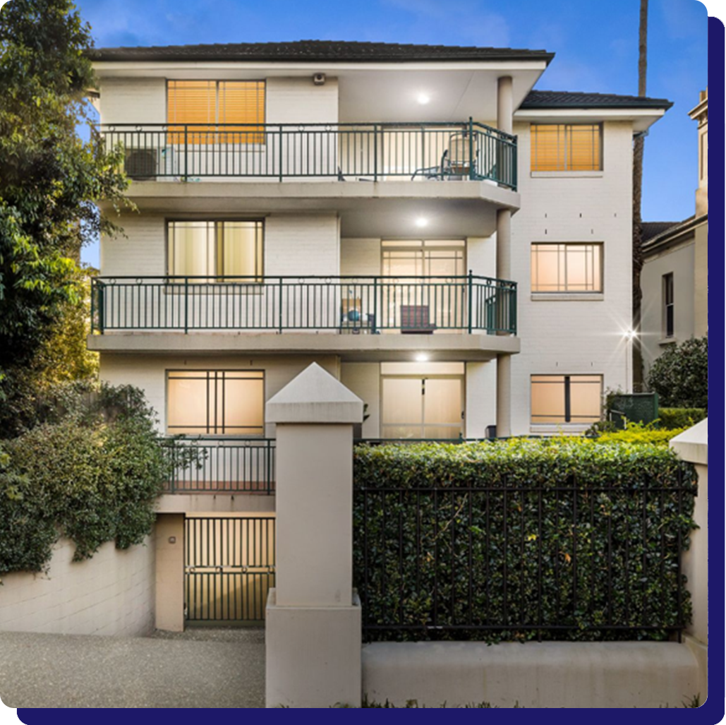 A large white apartment building with a lot of windows and balconies.